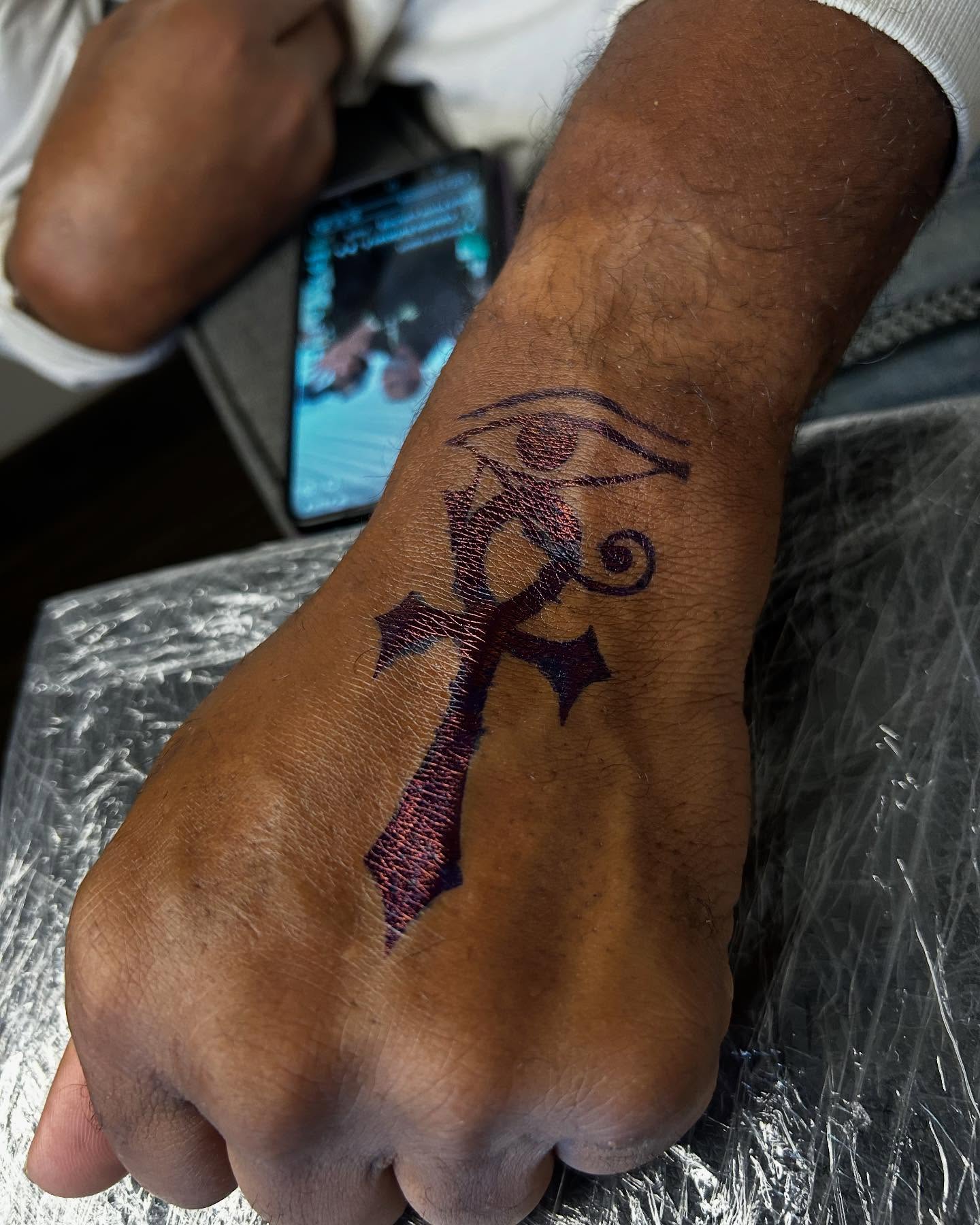 Eye of horus cross American traditional tattoo on the forearm by Airika Edwards