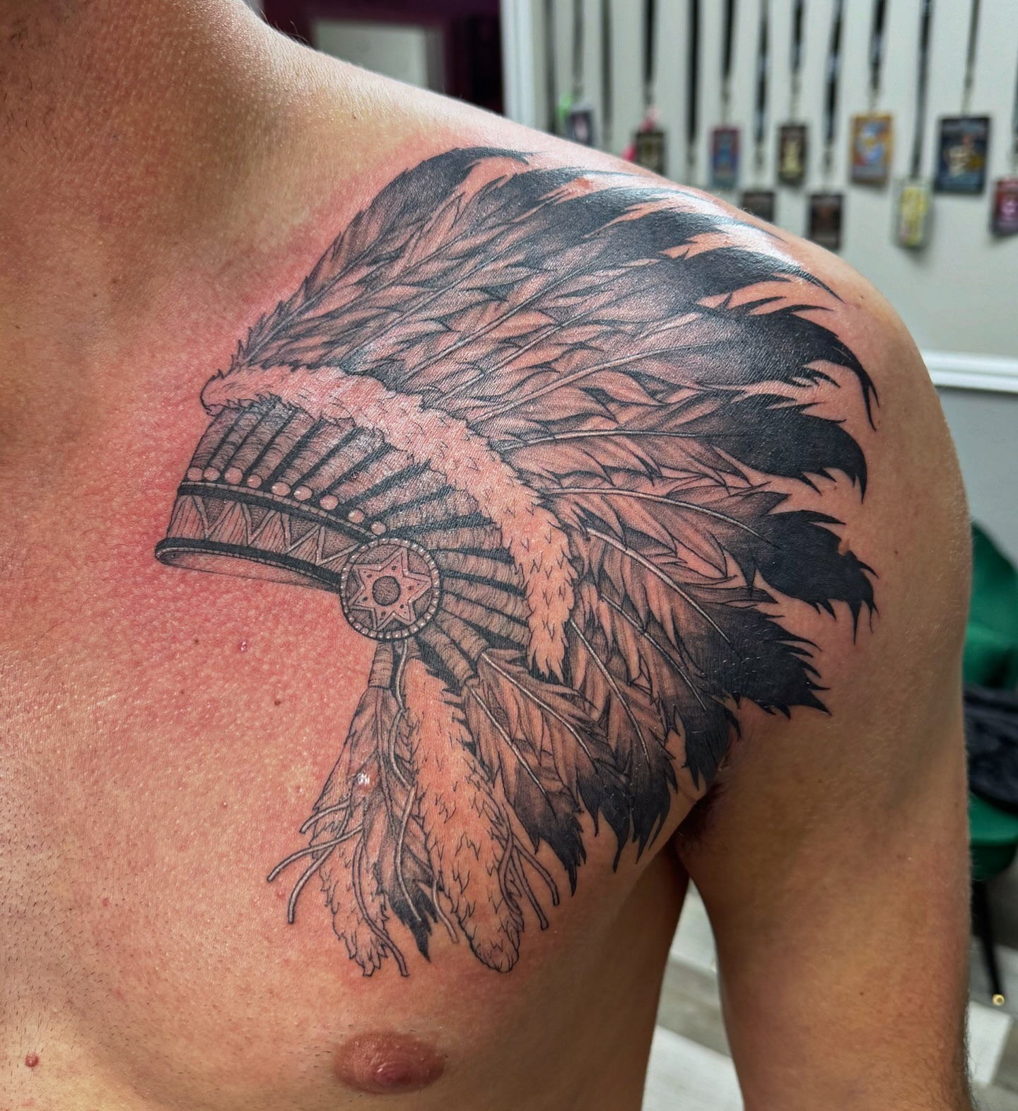 Native headdress black and grey tattoo on the shoulder by Mo Dinero🎰