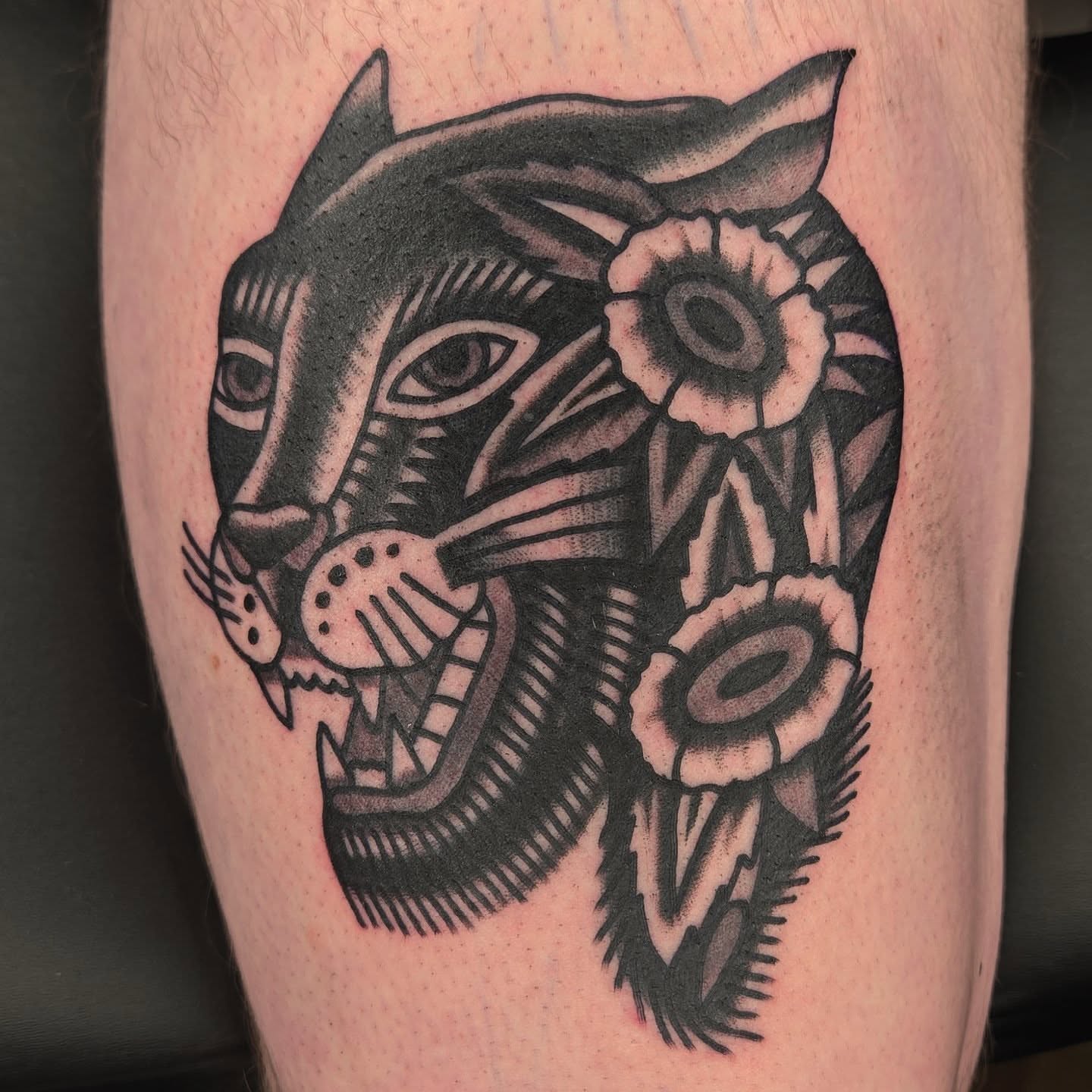 Panther with flowers American traditional tattoo on the forearm by Deke Harms, Bend, Oregon