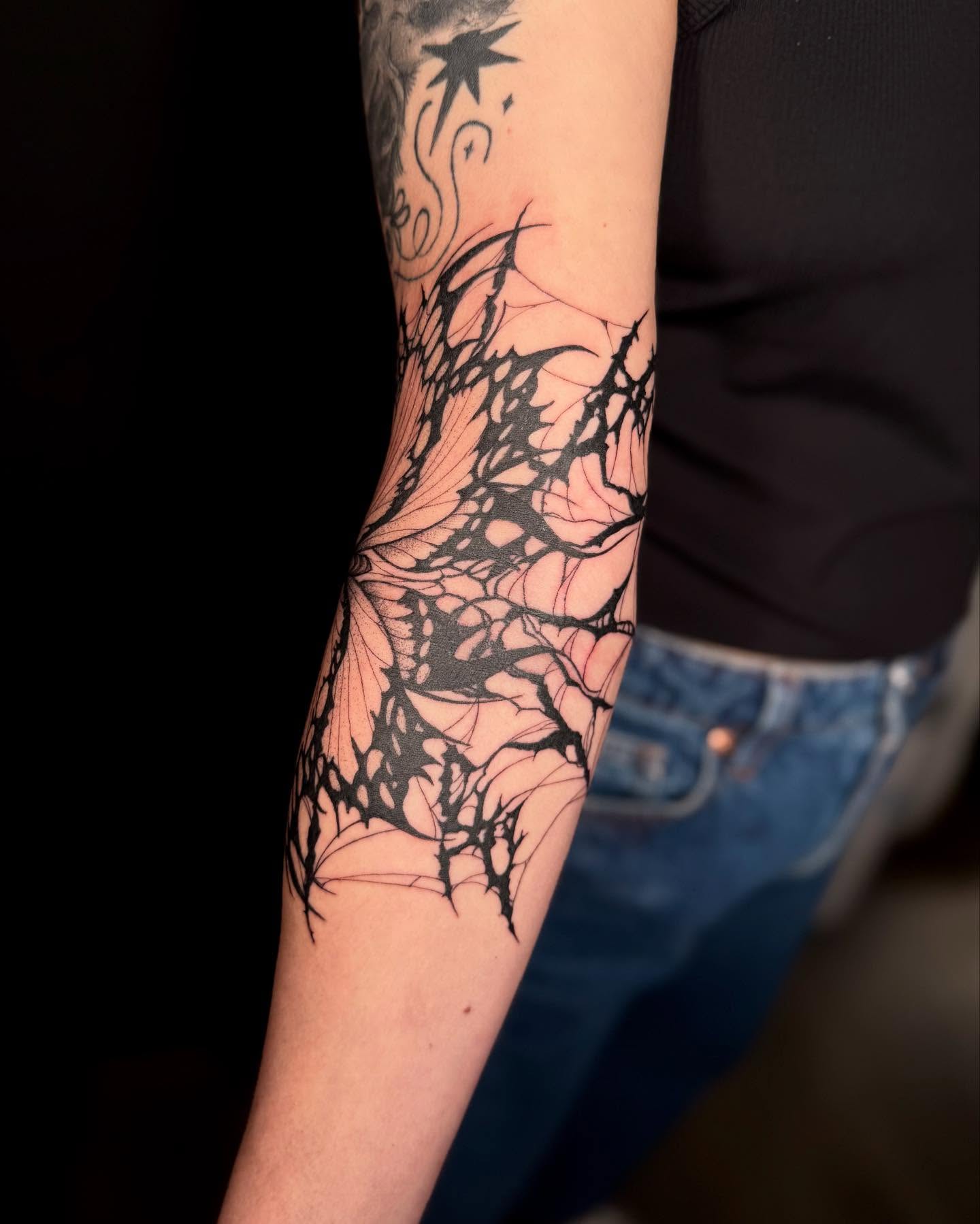 Spiderweb blackwork tattoo on the forearm by Koko