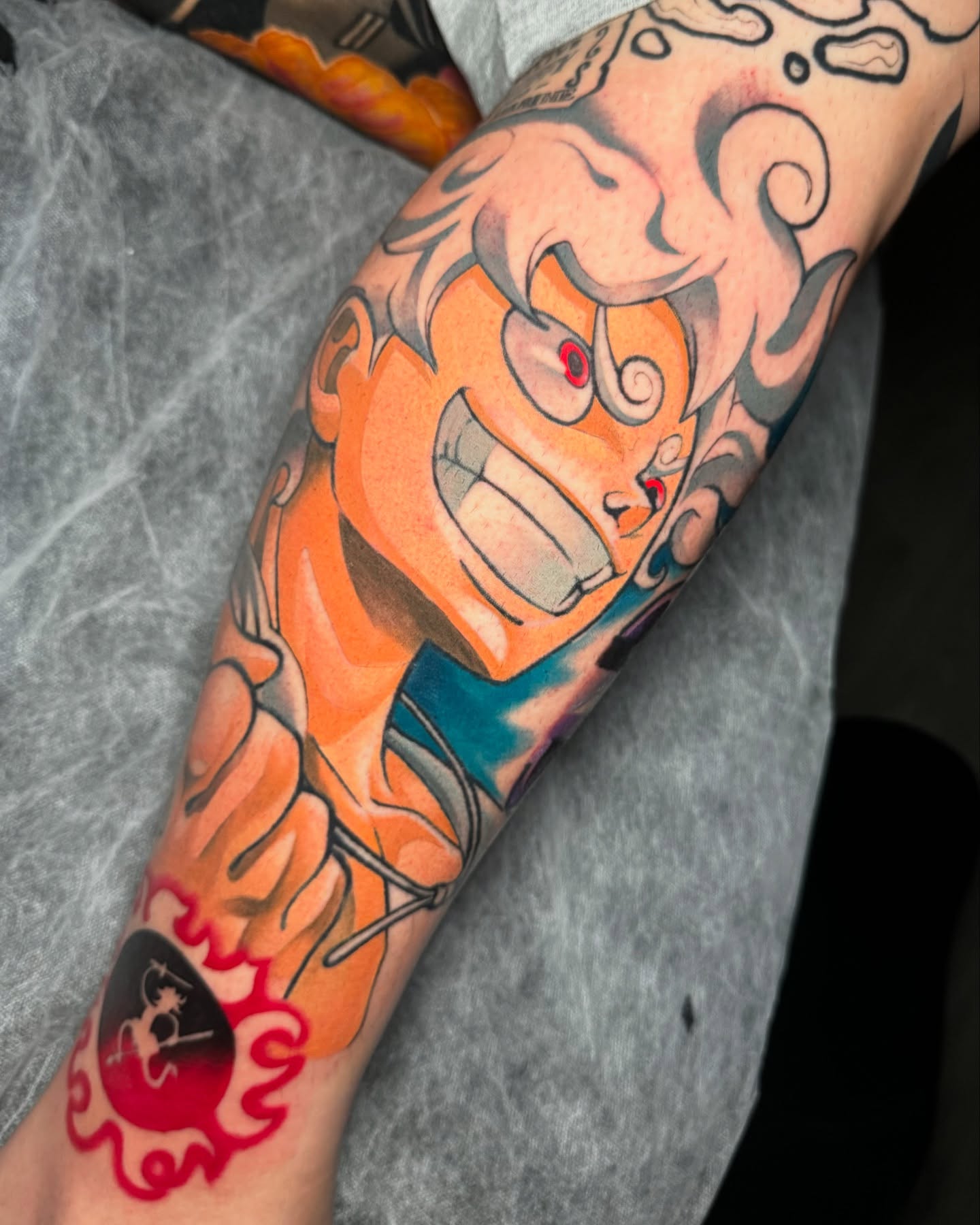 Orange demon anime tattoo on the forearm by Cristian Romero