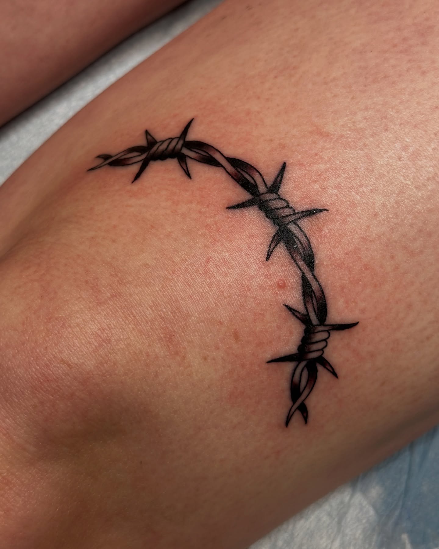 Barbed wire black and grey tattoo on the forearm by Michael Williams