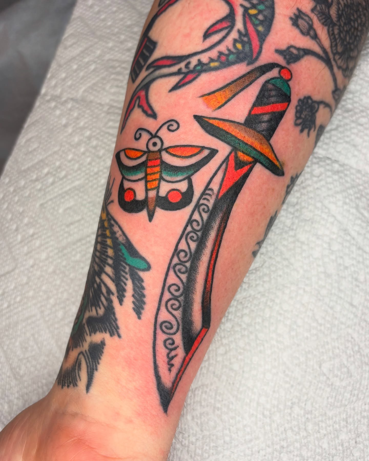 Insect and dagger American traditional tattoo on the forearm by Charlie Dunkel Tattoo