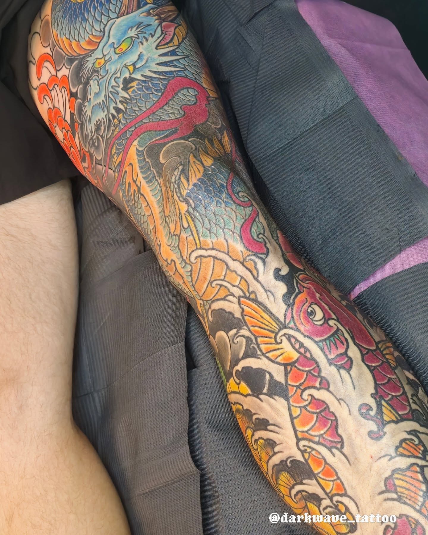 Dragon and koi fish American traditional tattoo on the forearm by Barrett Handel