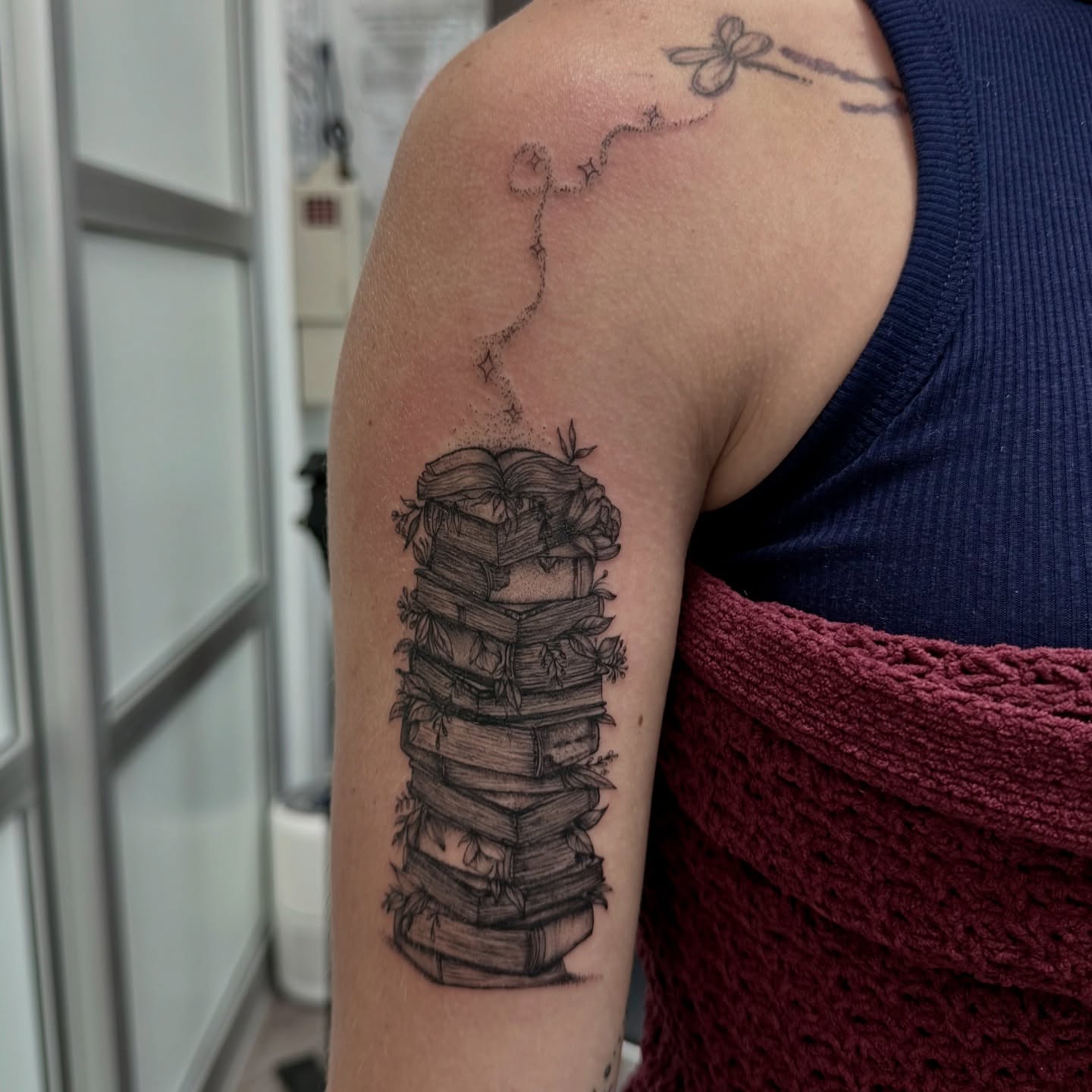 Stack of books dotwork tattoo on the forearm by Syd Cheyenne