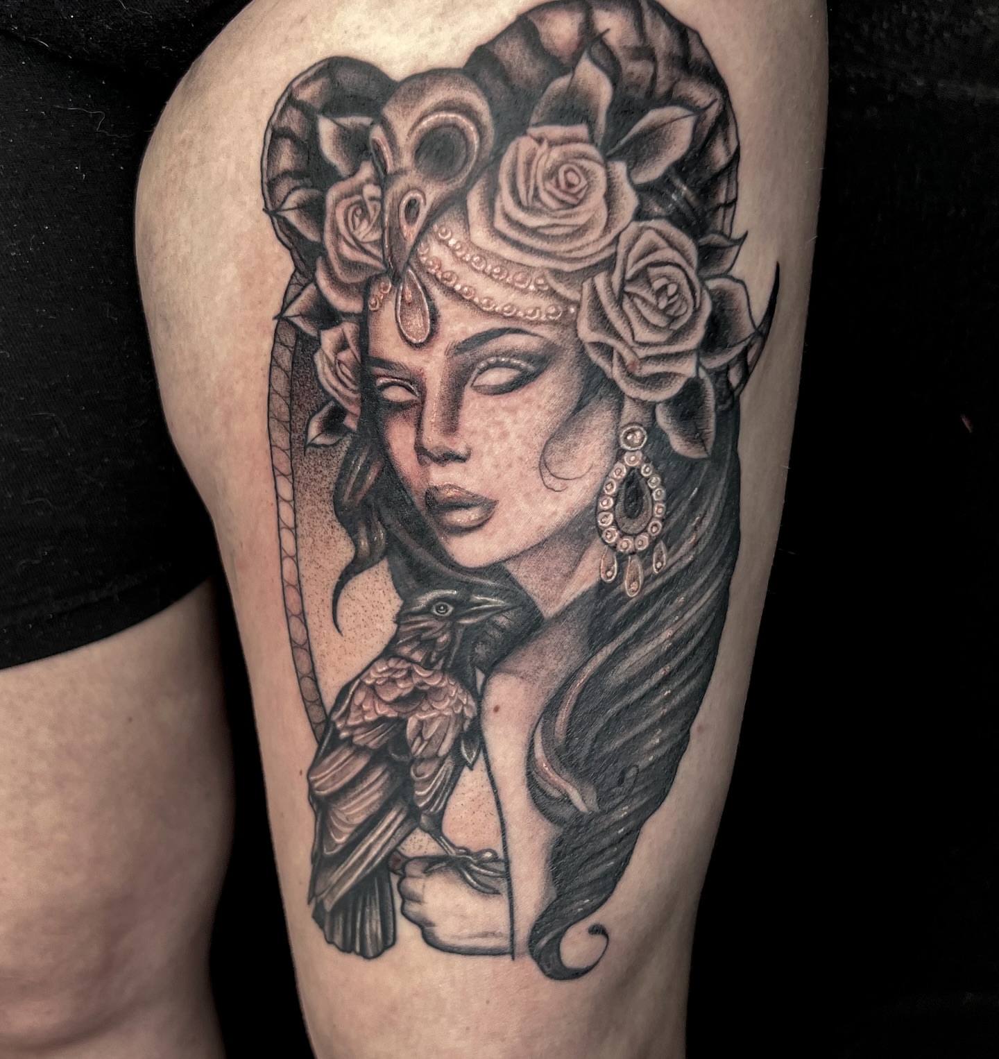 Woman with roses and crow realism tattoo on the thigh by Jordyn Tinney