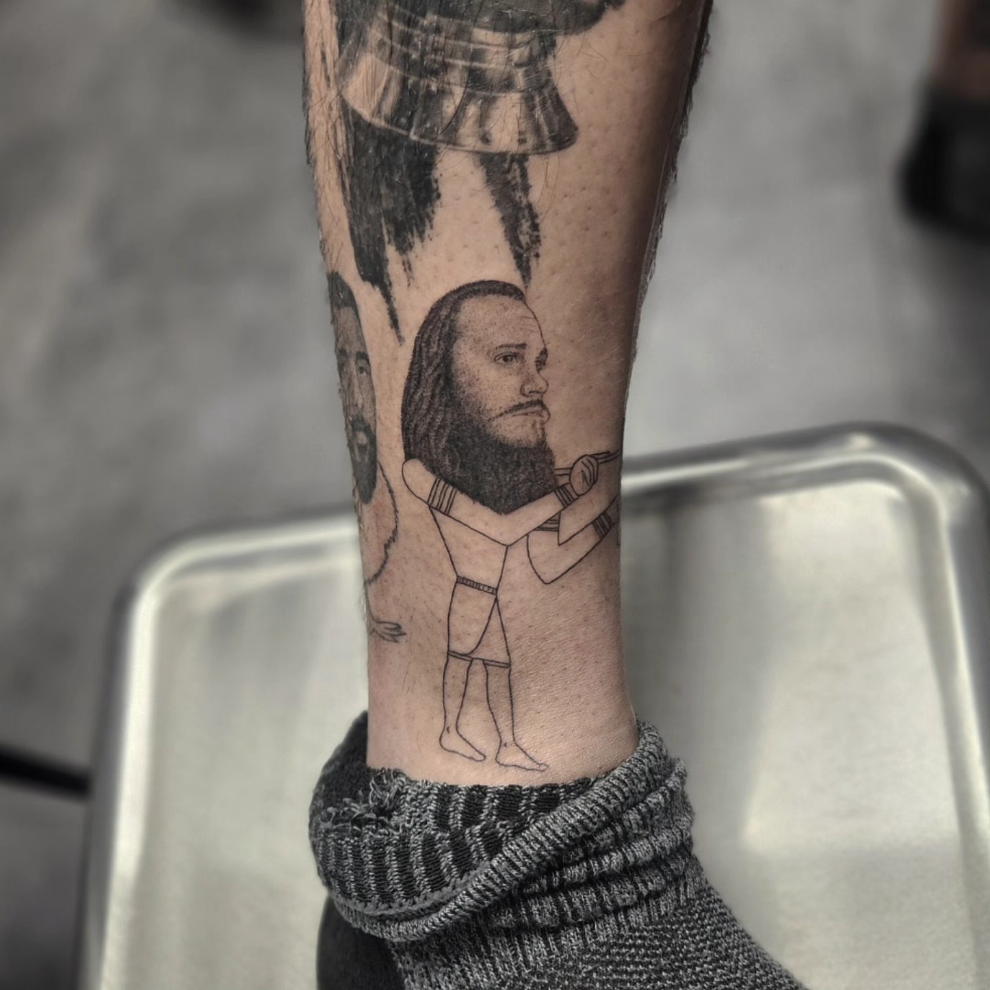 Bearded man black and grey tattoo on the forearm by Kyle Joseph [tattoo artist]