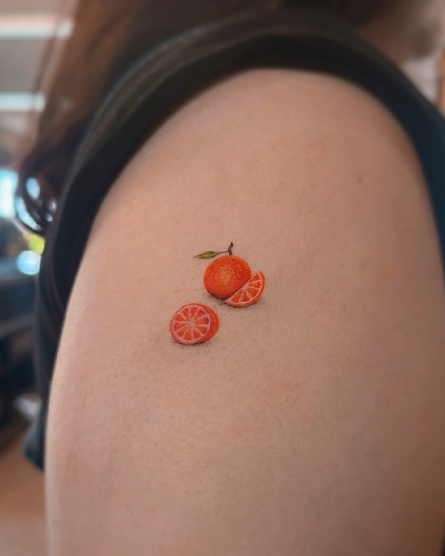 Orange slices realism tattoo on the shoulder by Lily K.