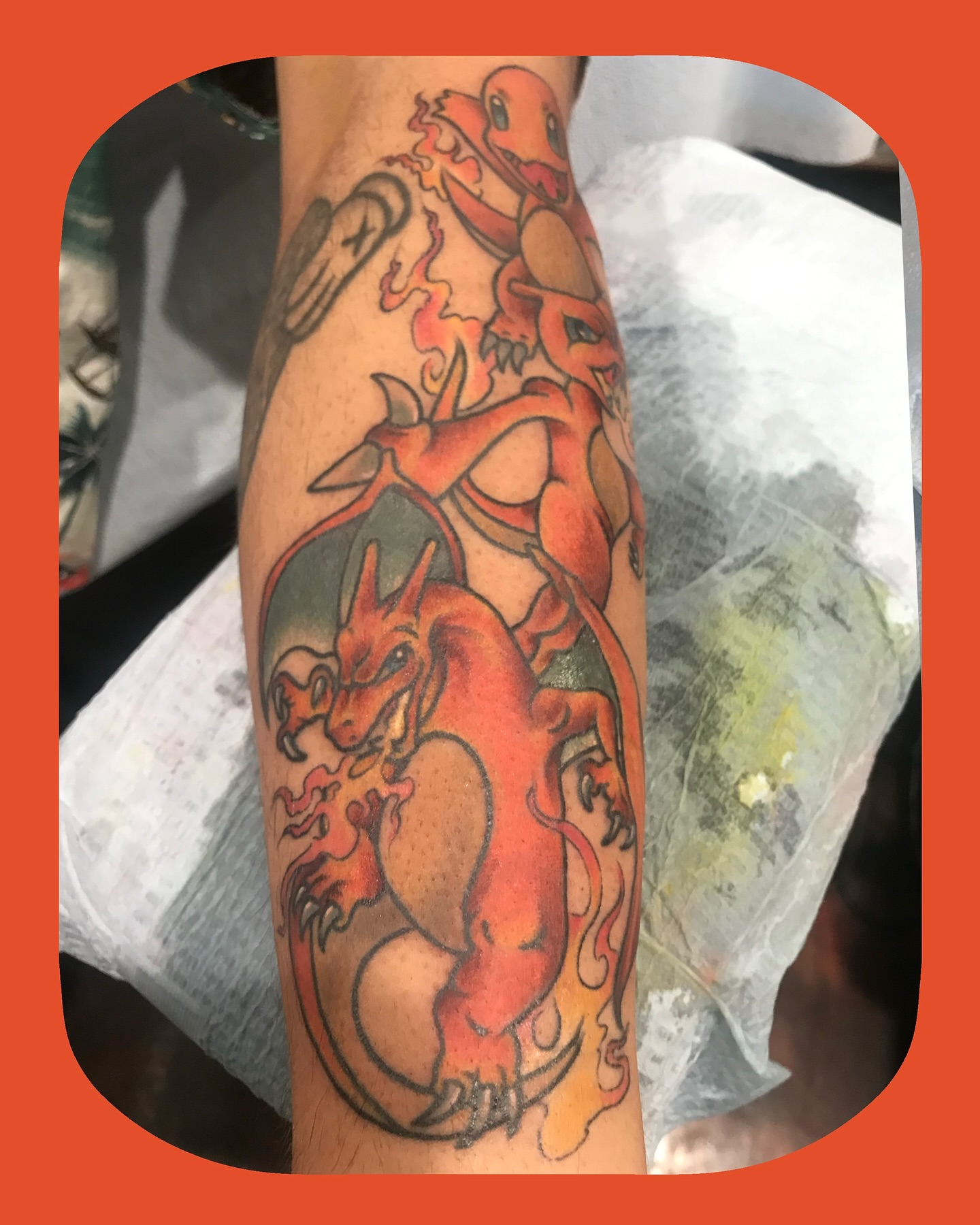 Dragon and charizard American traditional tattoo on the forearm by Chris Chapman