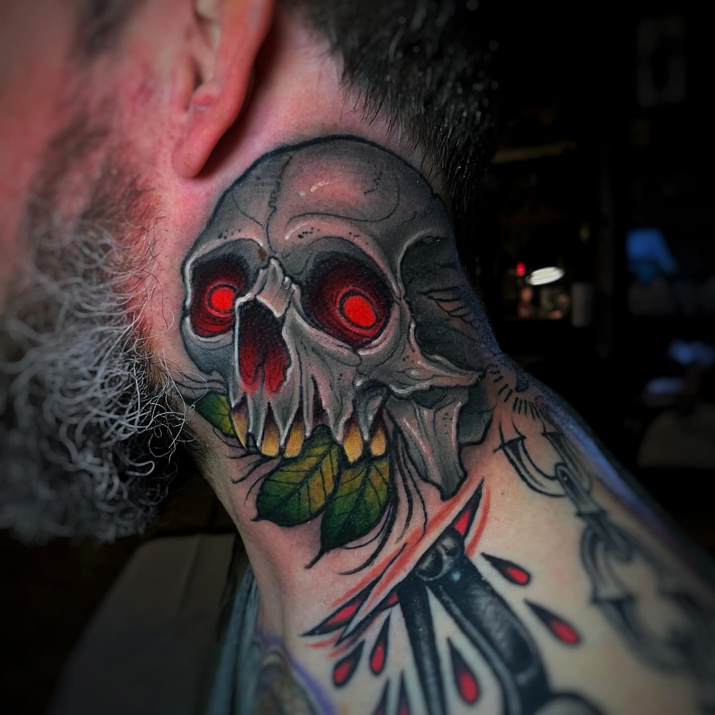 Skull with glowing eyes dark realism tattoo on the neck by Ick Abrams