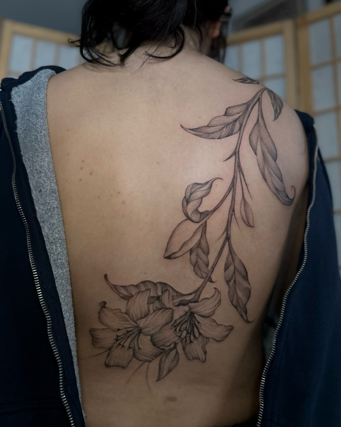 Flower and leaves black and grey tattoo on the back by cora cupid