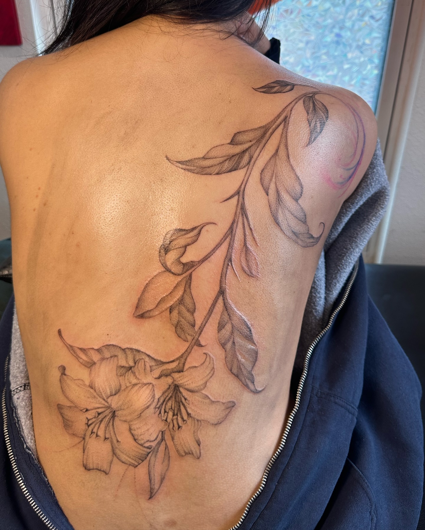 Flower and leaves black and grey tattoo on the back by cora cupid