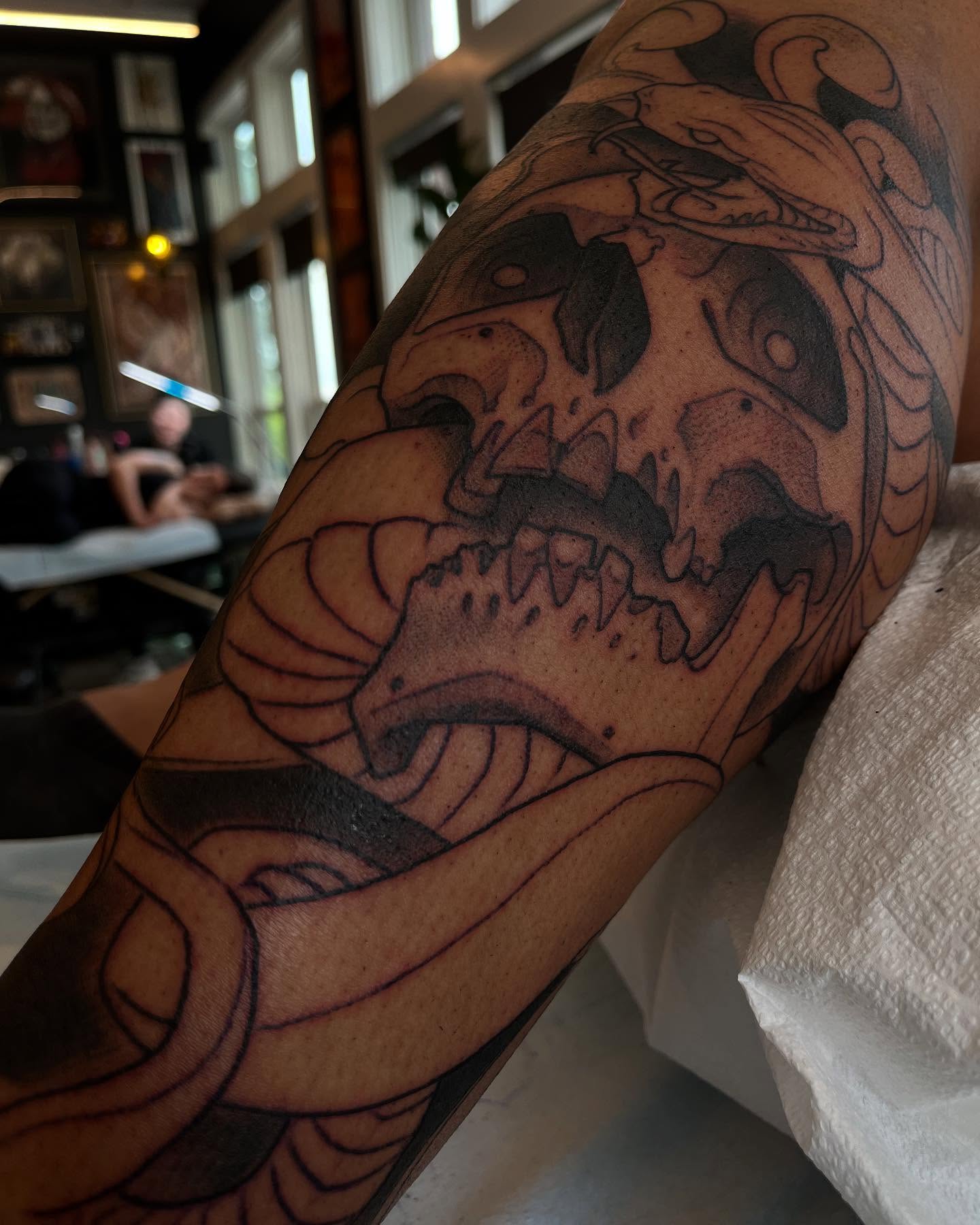 Skull with snake black and grey tattoo on the forearm by Ian White