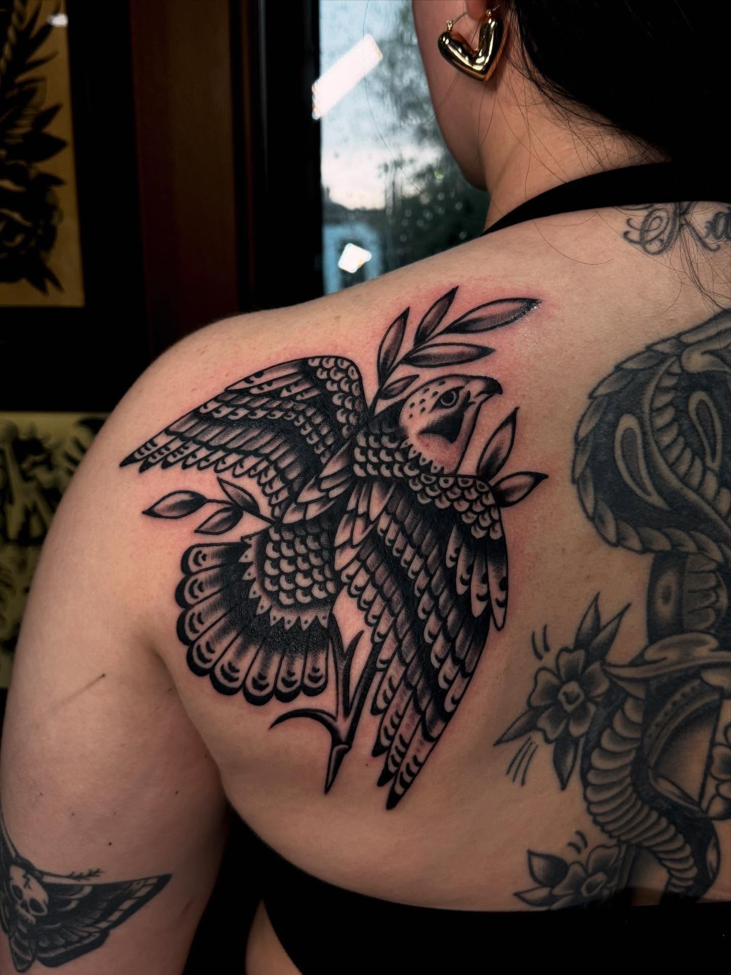 Hawk with leaves American traditional tattoo on the shoulder by Ryan Engels