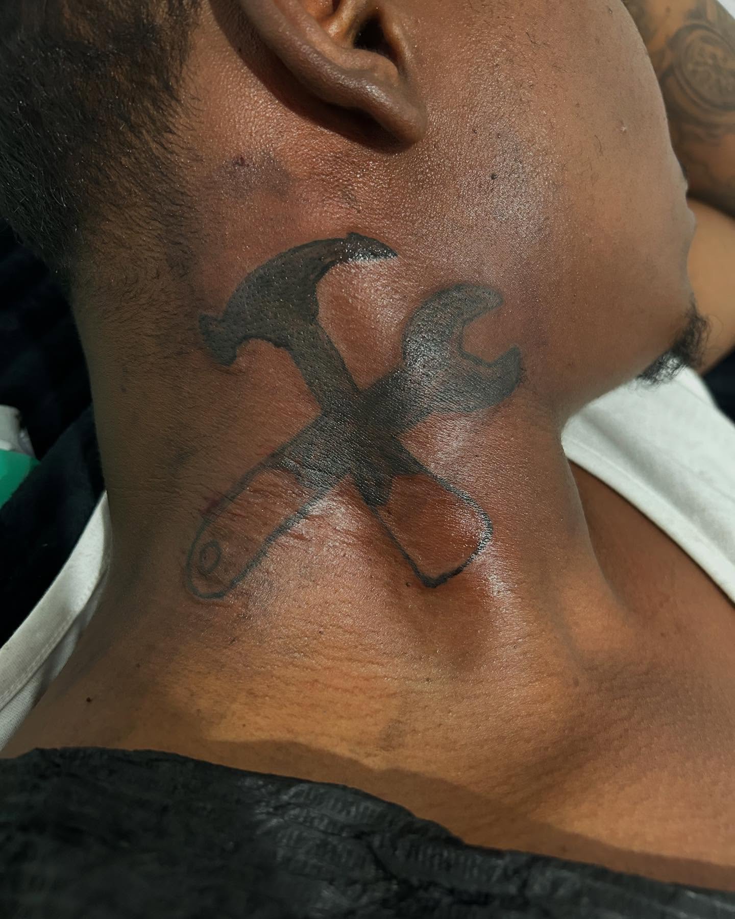 Hammer and wrench black and grey tattoo on the neck by Airika Edwards