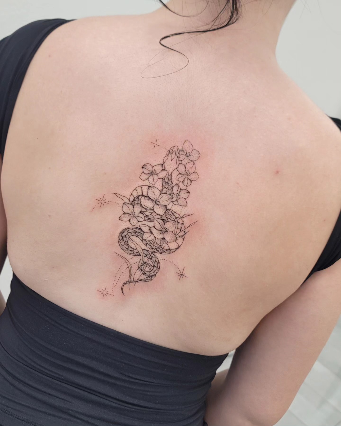 Flower bouquet black and grey tattoo on the back by Las Vegas Fine Line Tattoos