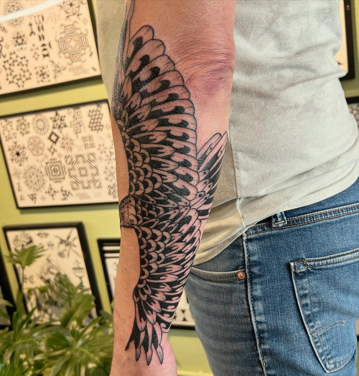 Wing black and grey tattoo on the forearm by Erica Finley