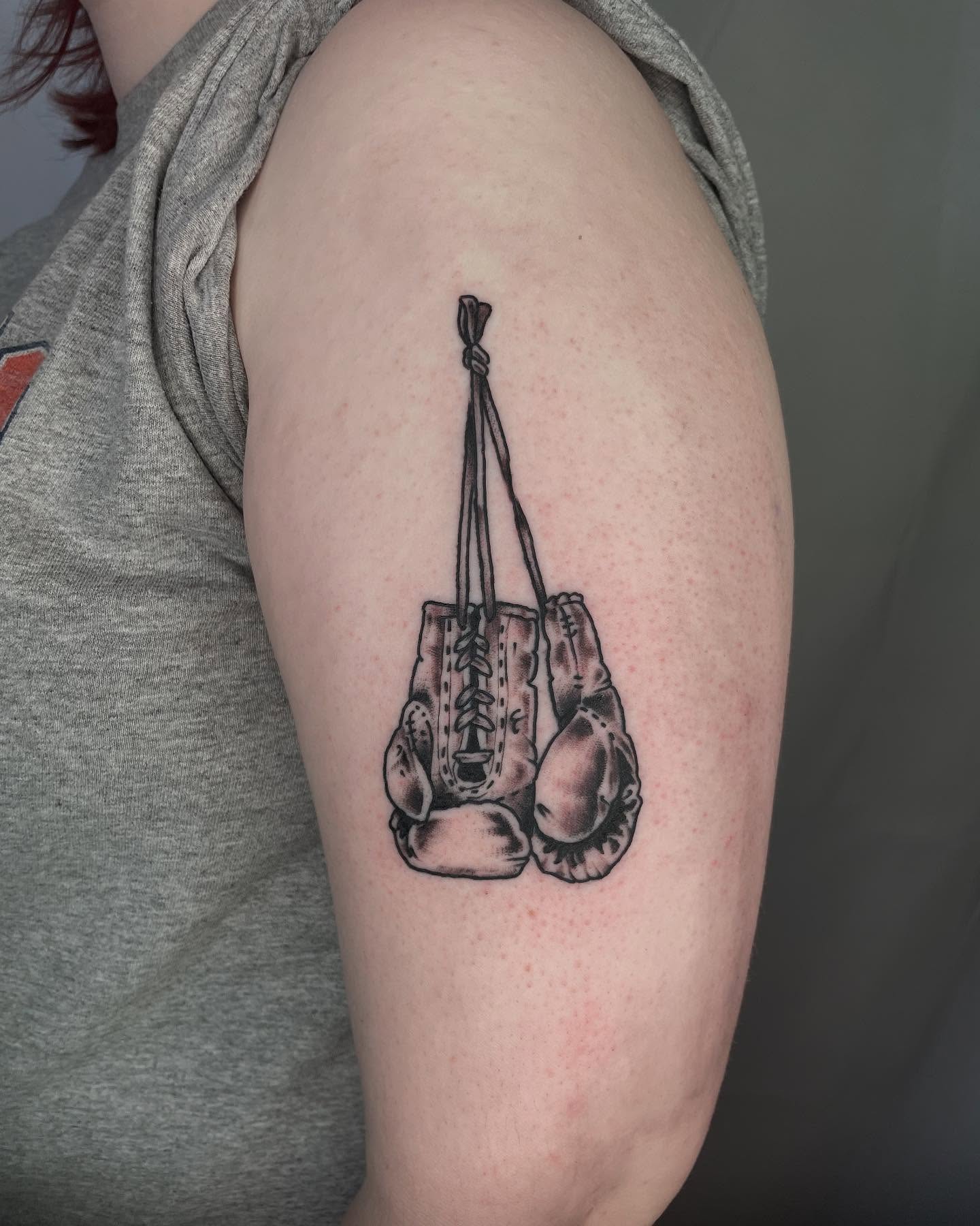 Boxing gloves black and grey tattoo on the shoulder by G. Clover ⚧︎, Chicago, Illinois