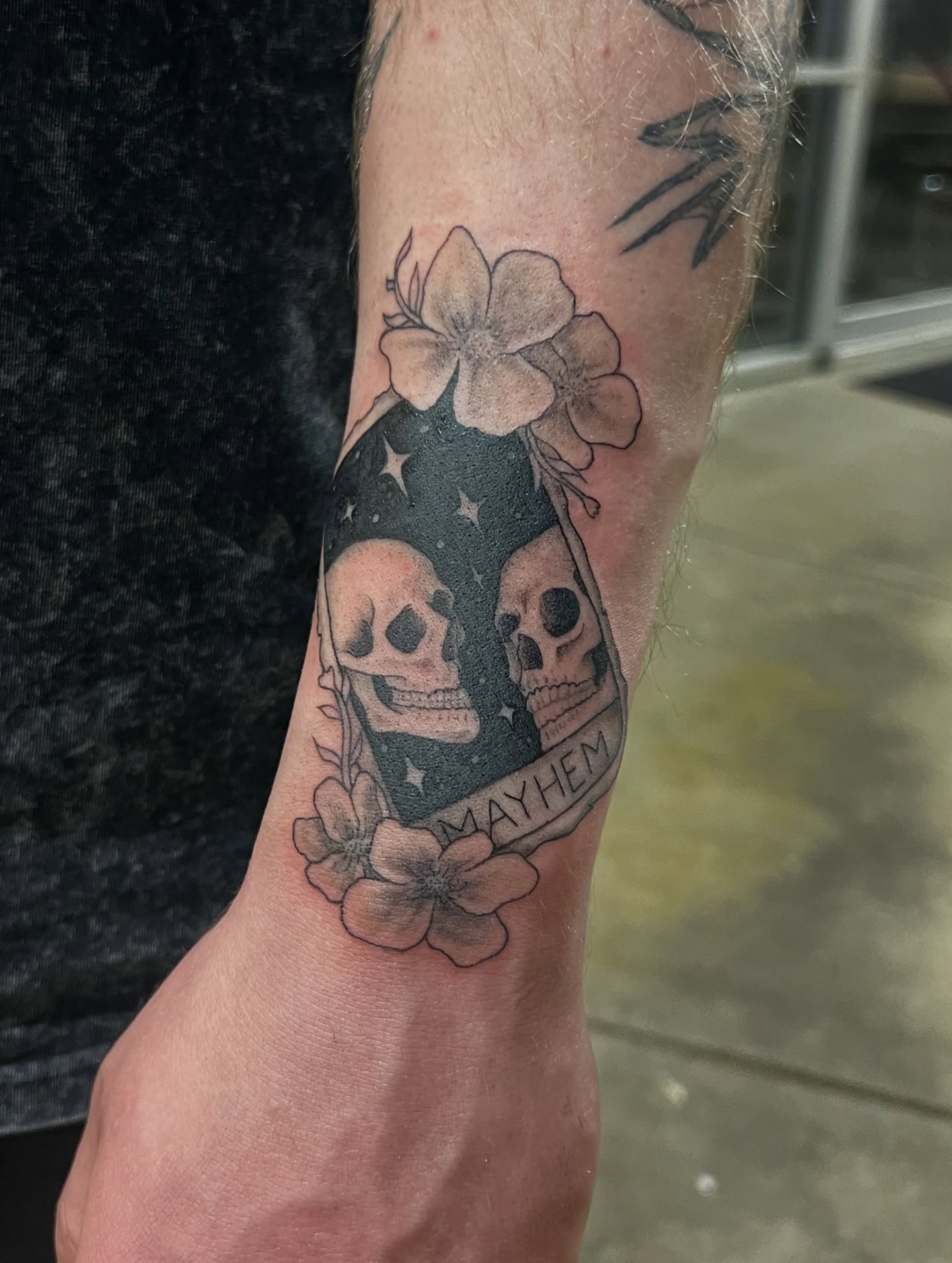 Skulls and flowers black and grey tattoo on the forearm by tatman cris 🥀 dfw tattoo artist