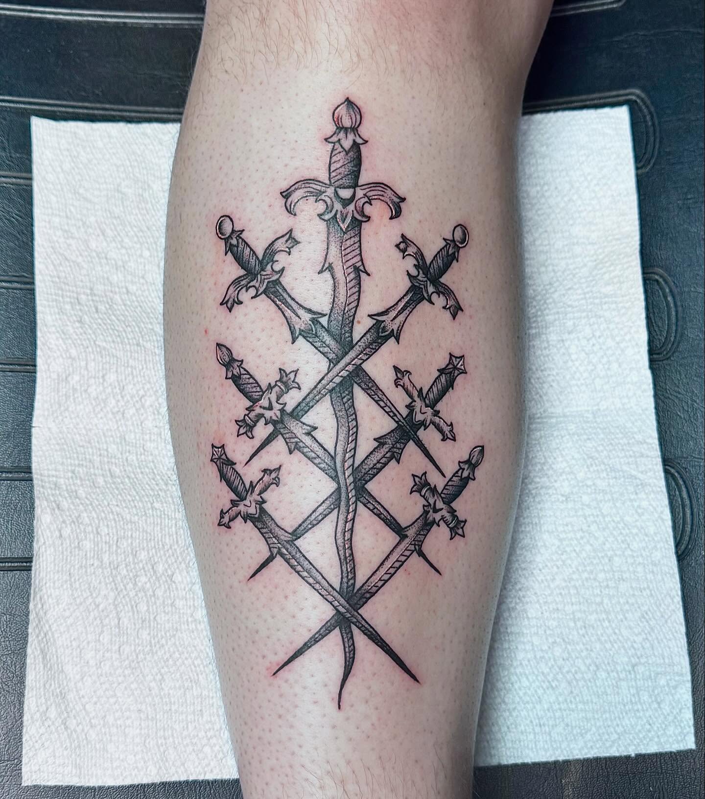 Crossed swords black and grey tattoo on the forearm by Colby McClain