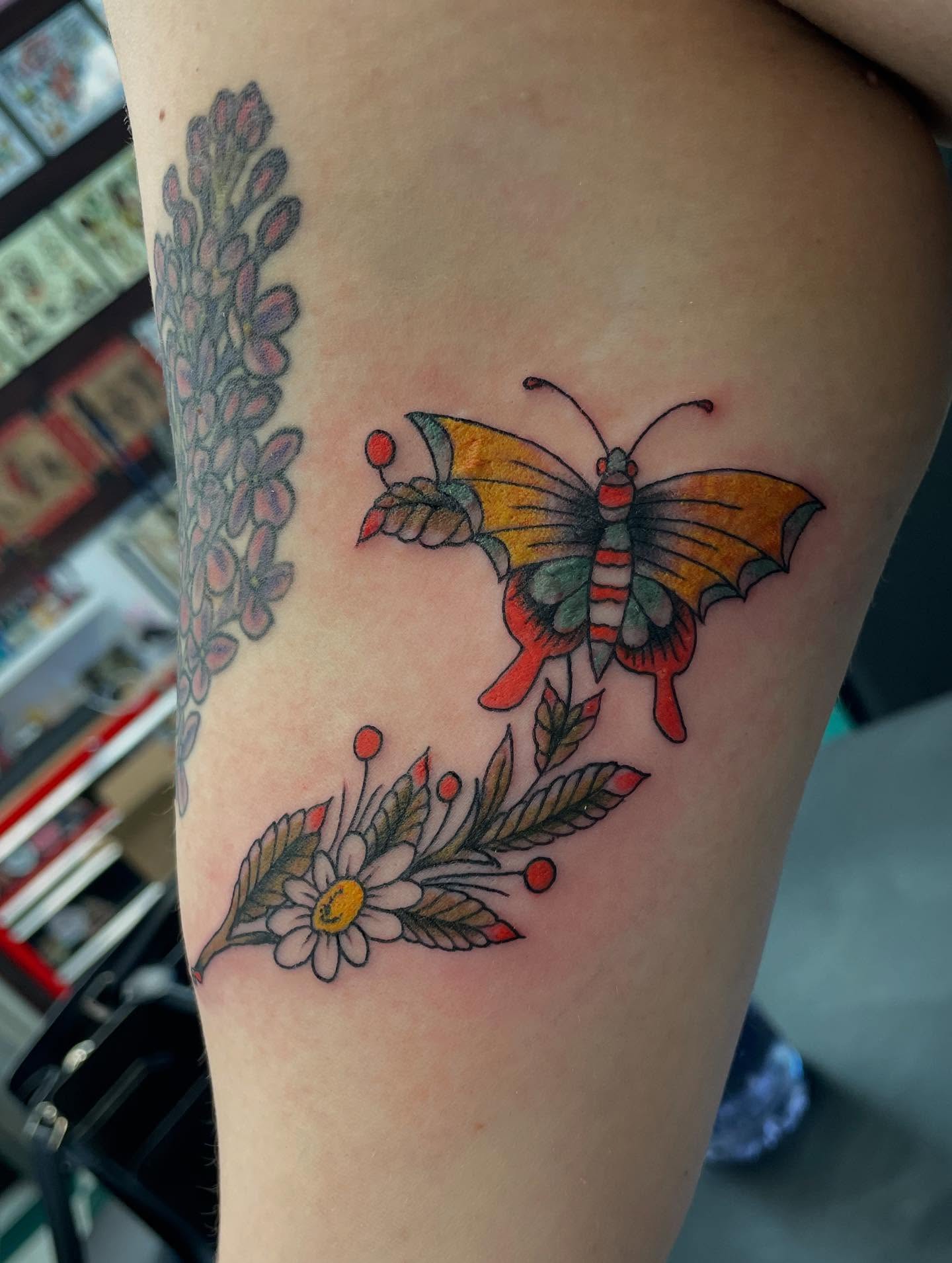 Butterfly and floral arrangement American traditional tattoo on the thigh by Dayton Tattoo Artist, Miamisburg, Ohio