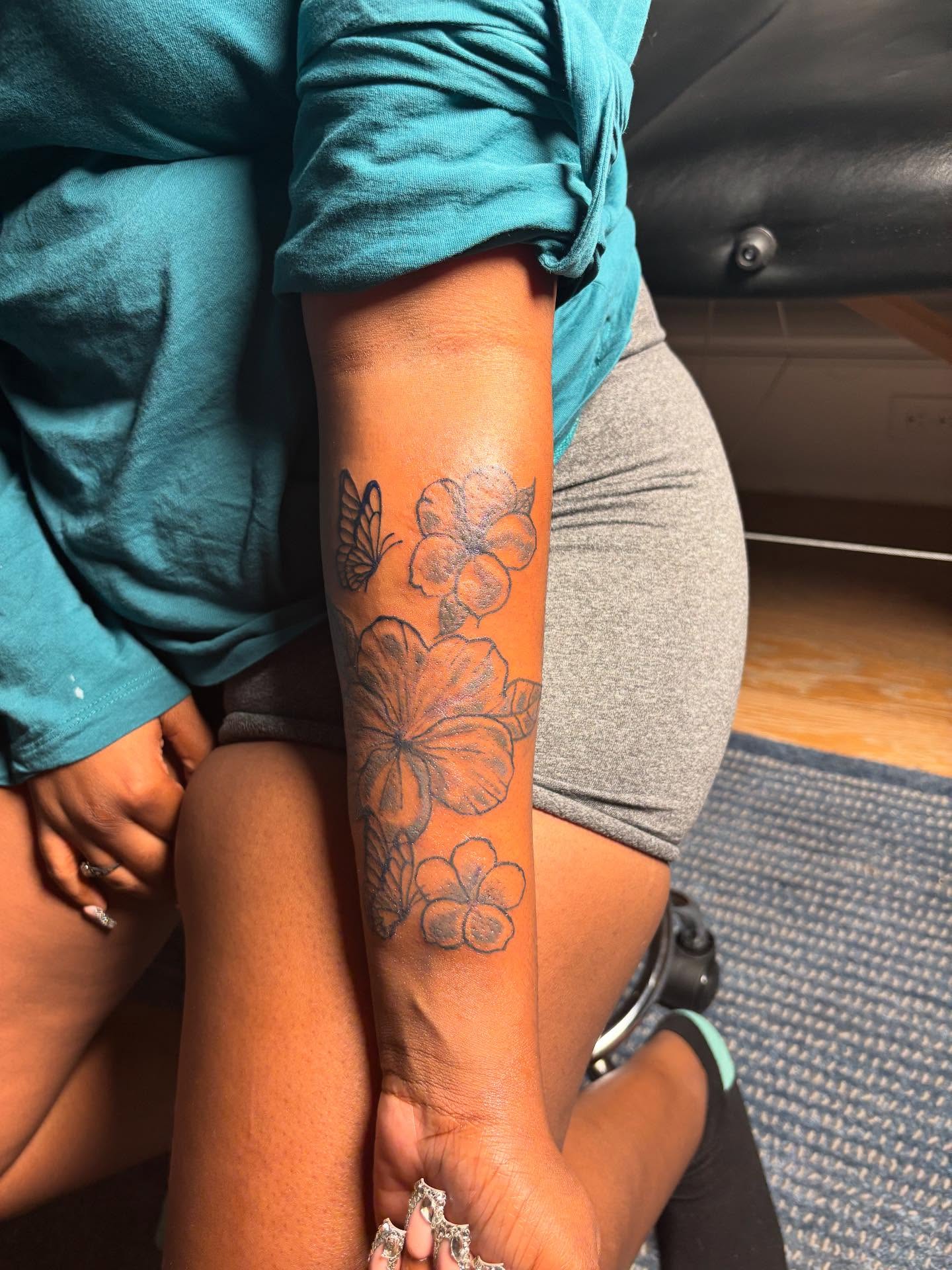 Flowers and butterfly black and grey tattoo on the forearm by Mc X Happo