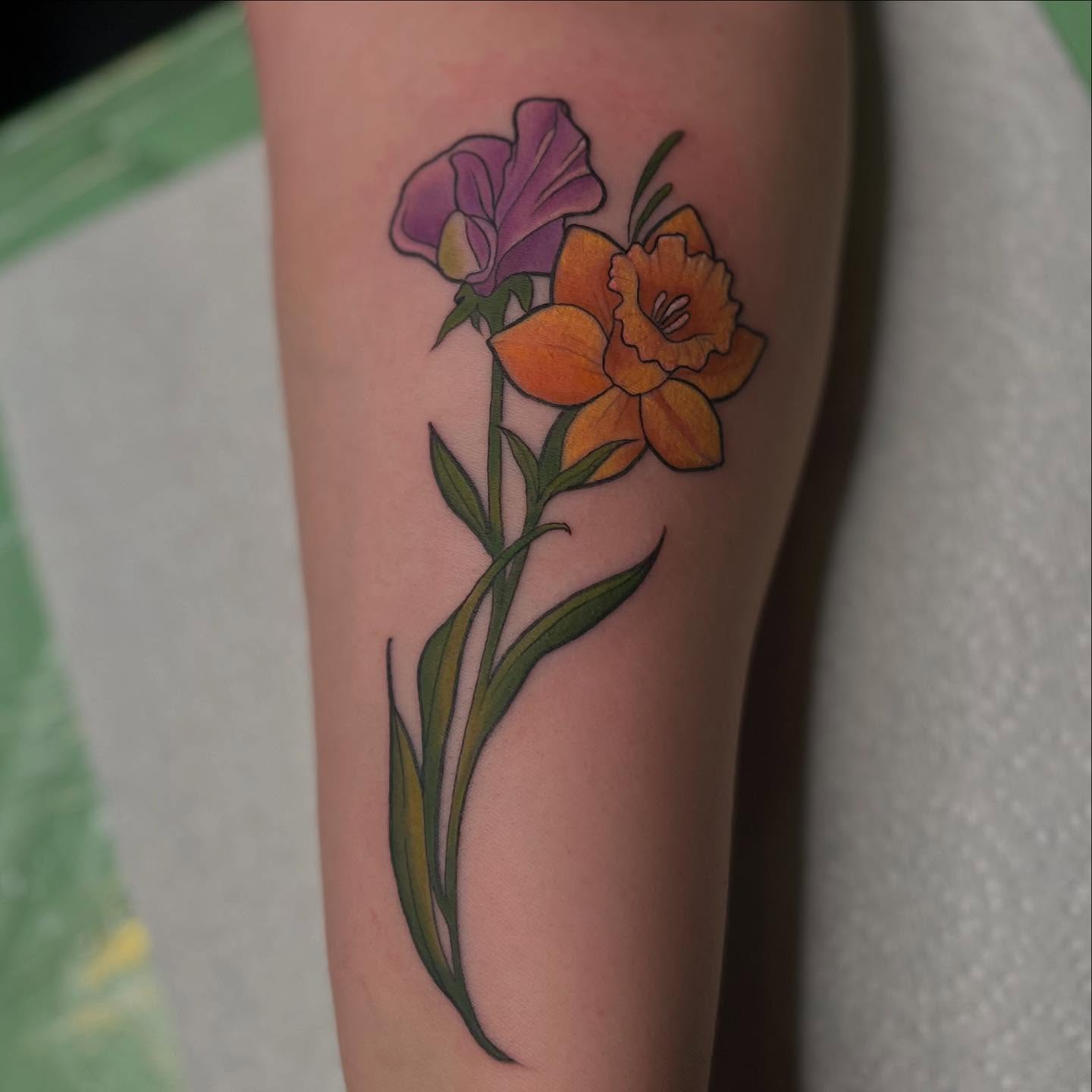 Daffodil and sweet pea realism tattoo on the forearm by Lexi Ross