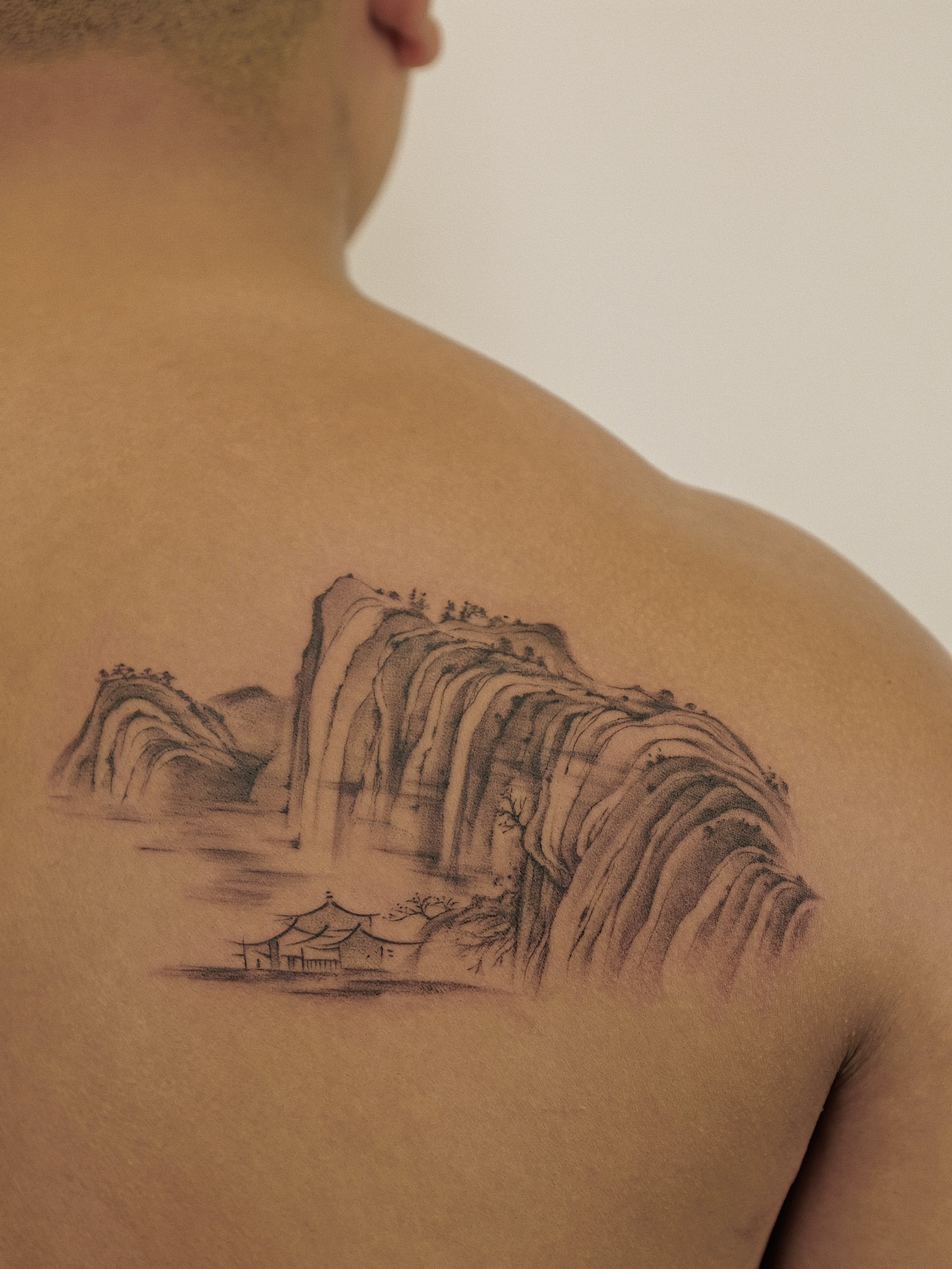 Landscape with waterfall realism tattoo on the back by Xiao Lun