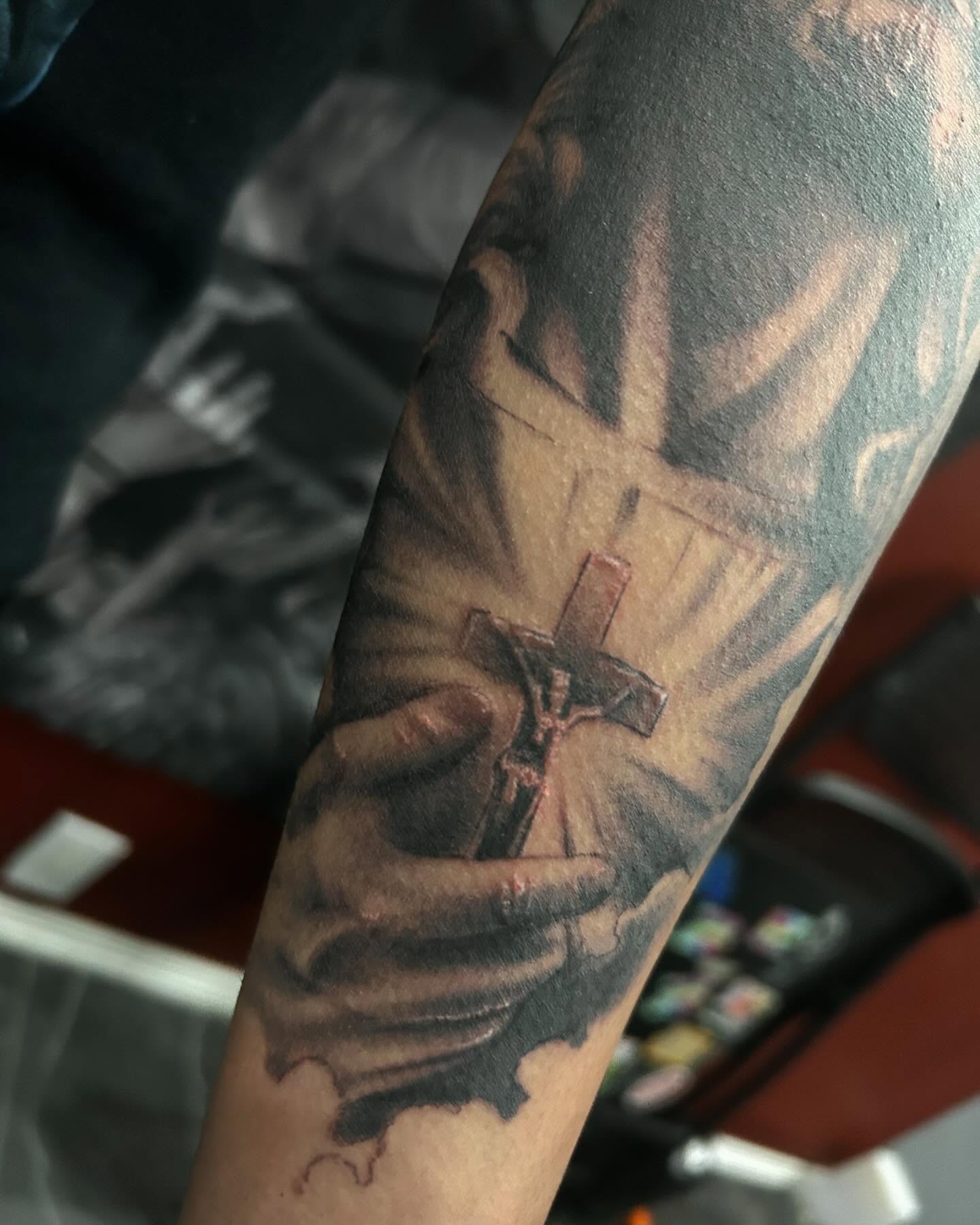 Cross and hands realism tattoo on the forearm by Carlos