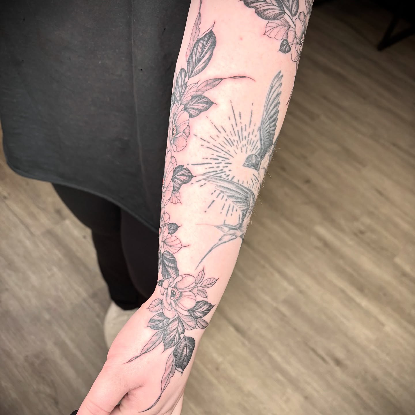 Flowers and bird black and grey tattoo on the forearm by Amber N