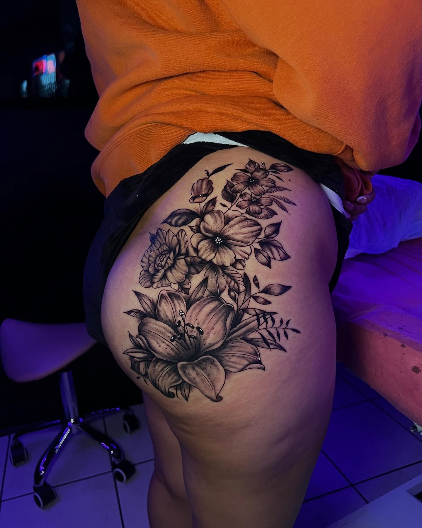 Floral arrangement black and grey tattoo on the thigh by Jasmin Lozano