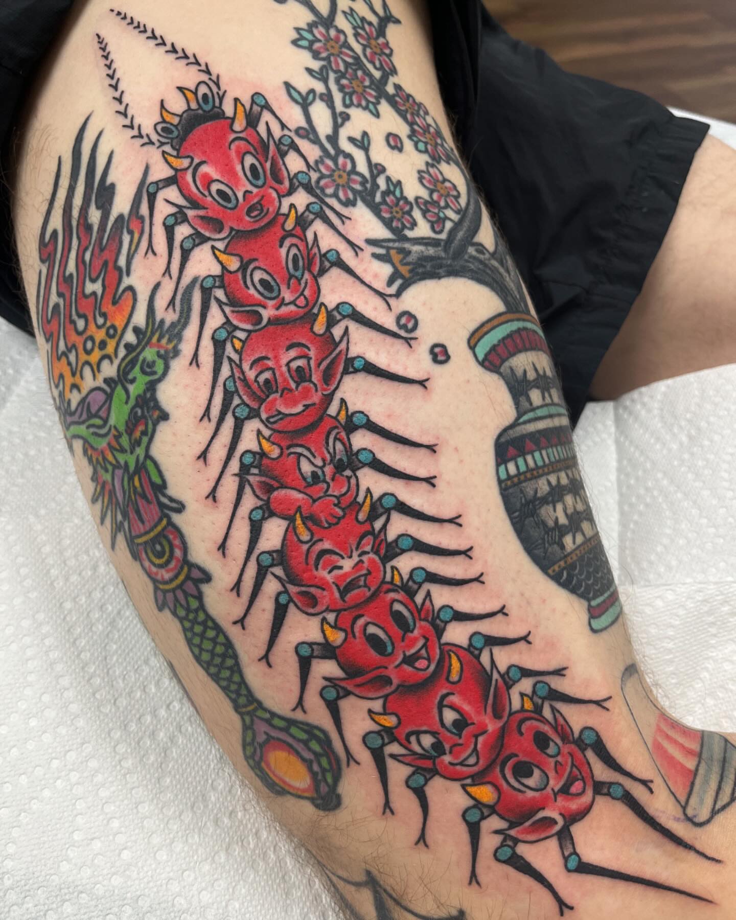 Red devils American traditional tattoo on the thigh by Brian Mcfadden