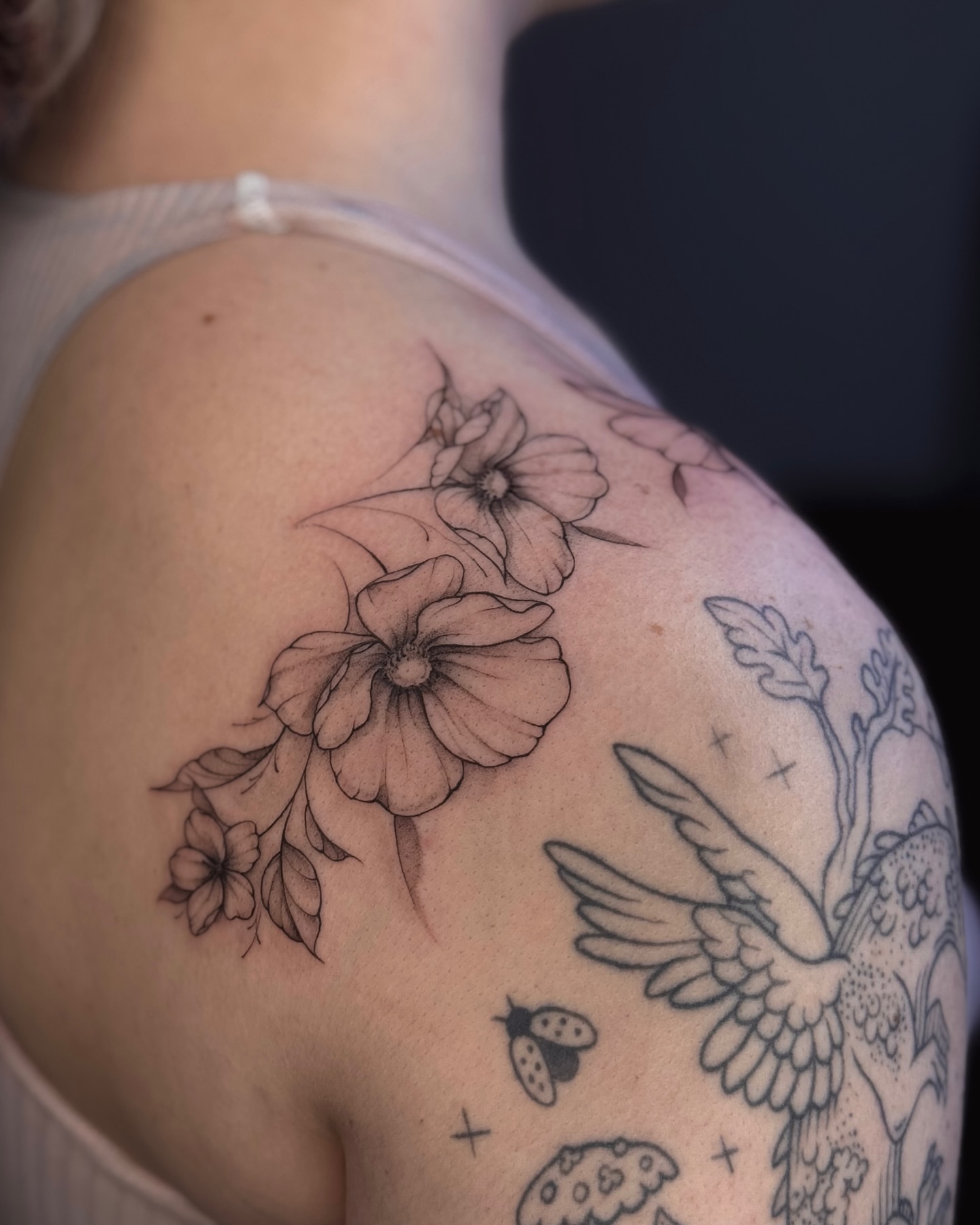 Flowers and bird black and grey tattoo on the shoulder by Daria
