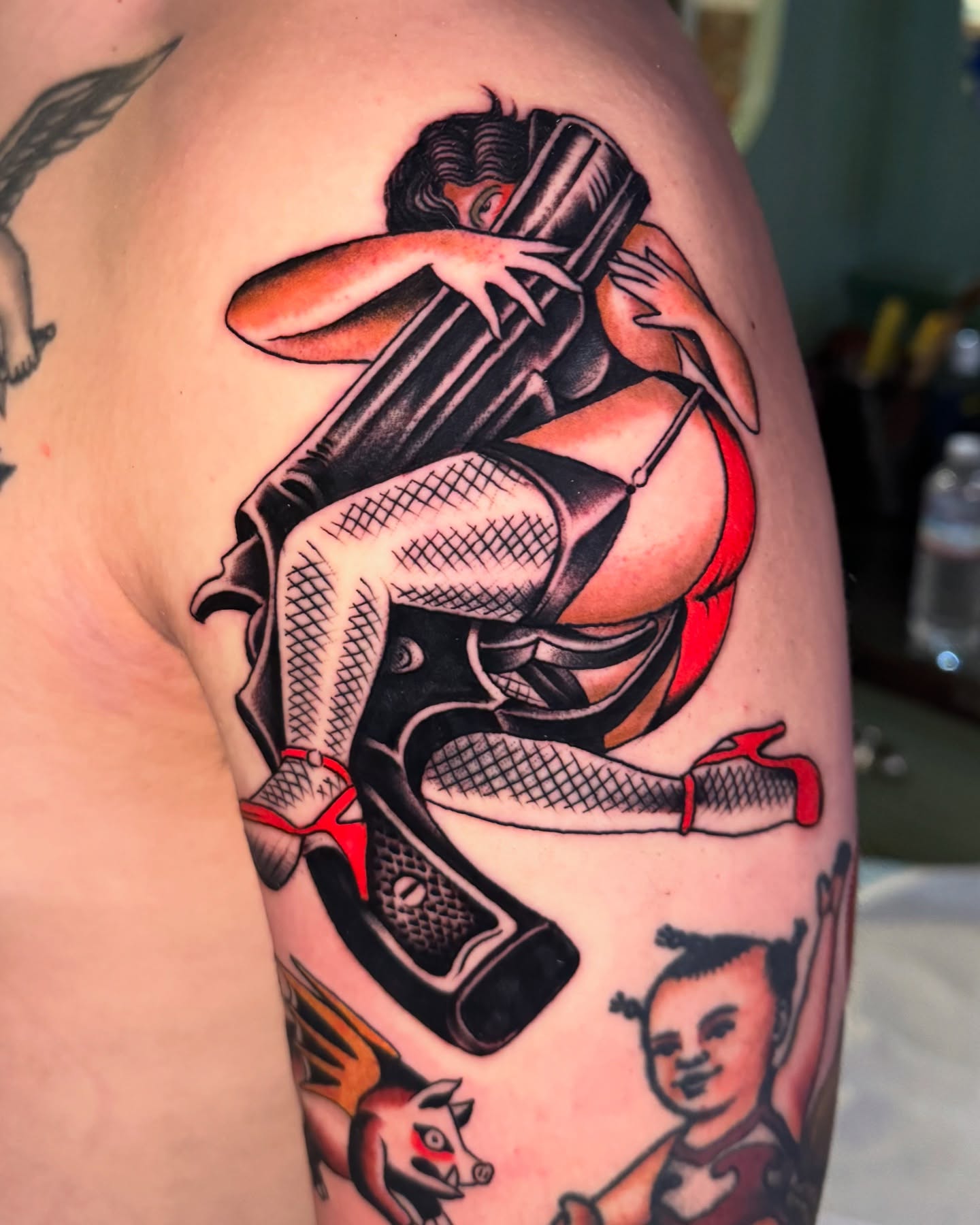 Gun and woman American traditional tattoo on the shoulder by Pavel