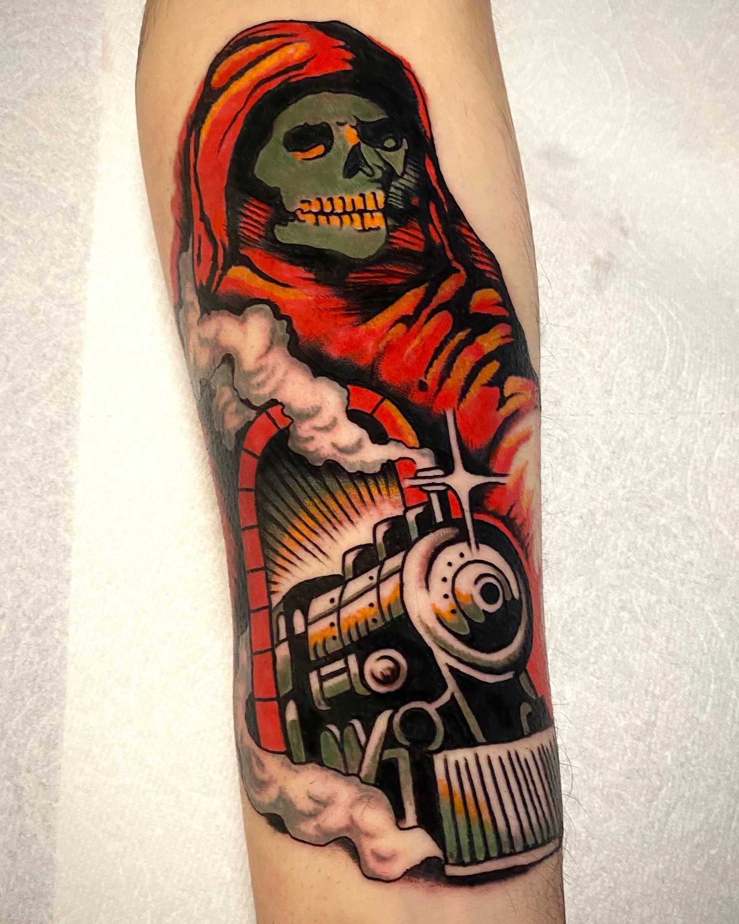 Grim reaper driving train American traditional tattoo on the forearm by Haley Tucker, Sebastopol, California
