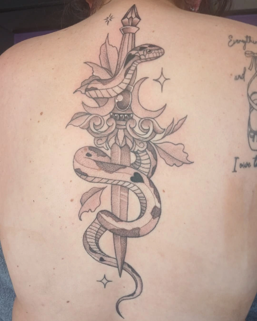 Snake and dagger geometric tattoo on the back by Cassieal Welch