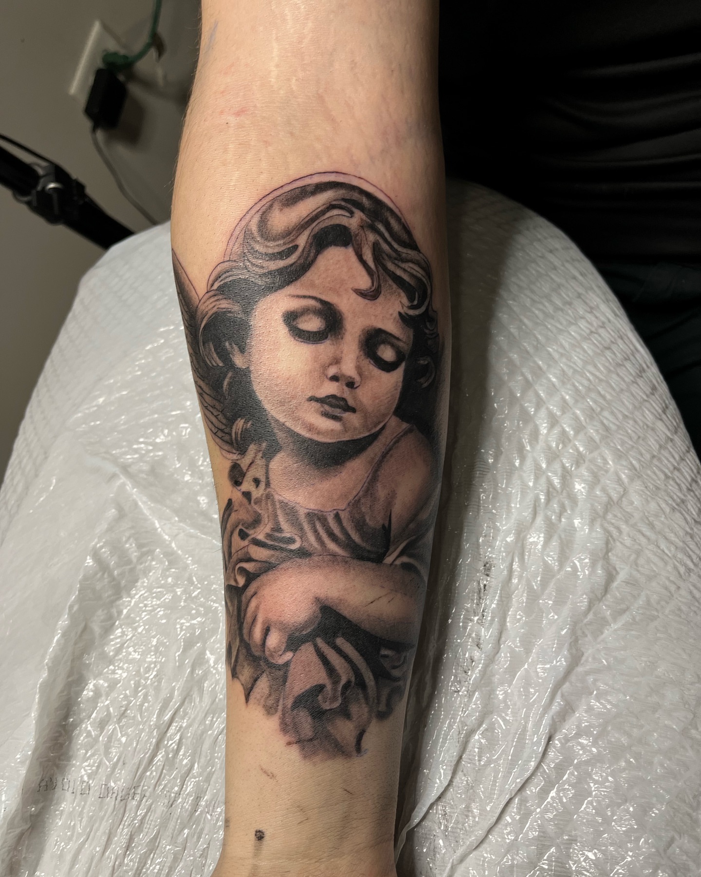 Child angel realism tattoo on the forearm by Brandon Patino