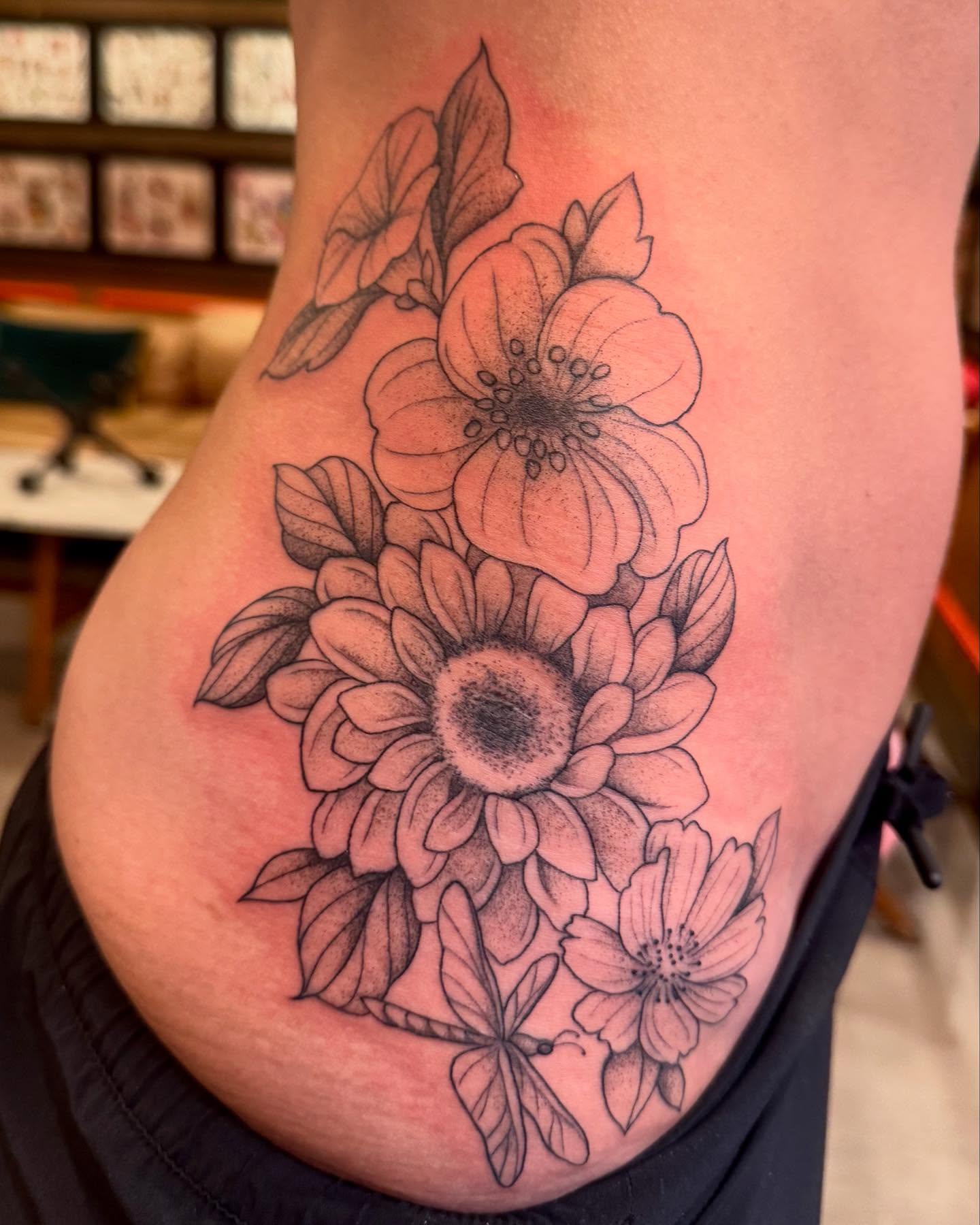 Flower bouquet black and grey tattoo on the thigh by Amber