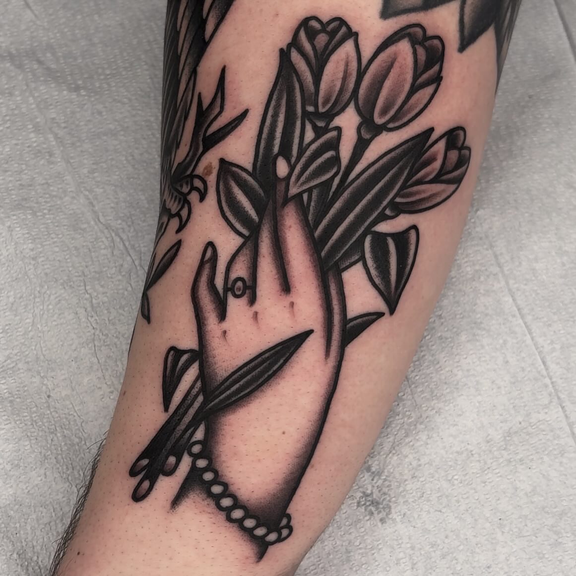 Hand with flowers black and grey tattoo on the forearm by John Lemon