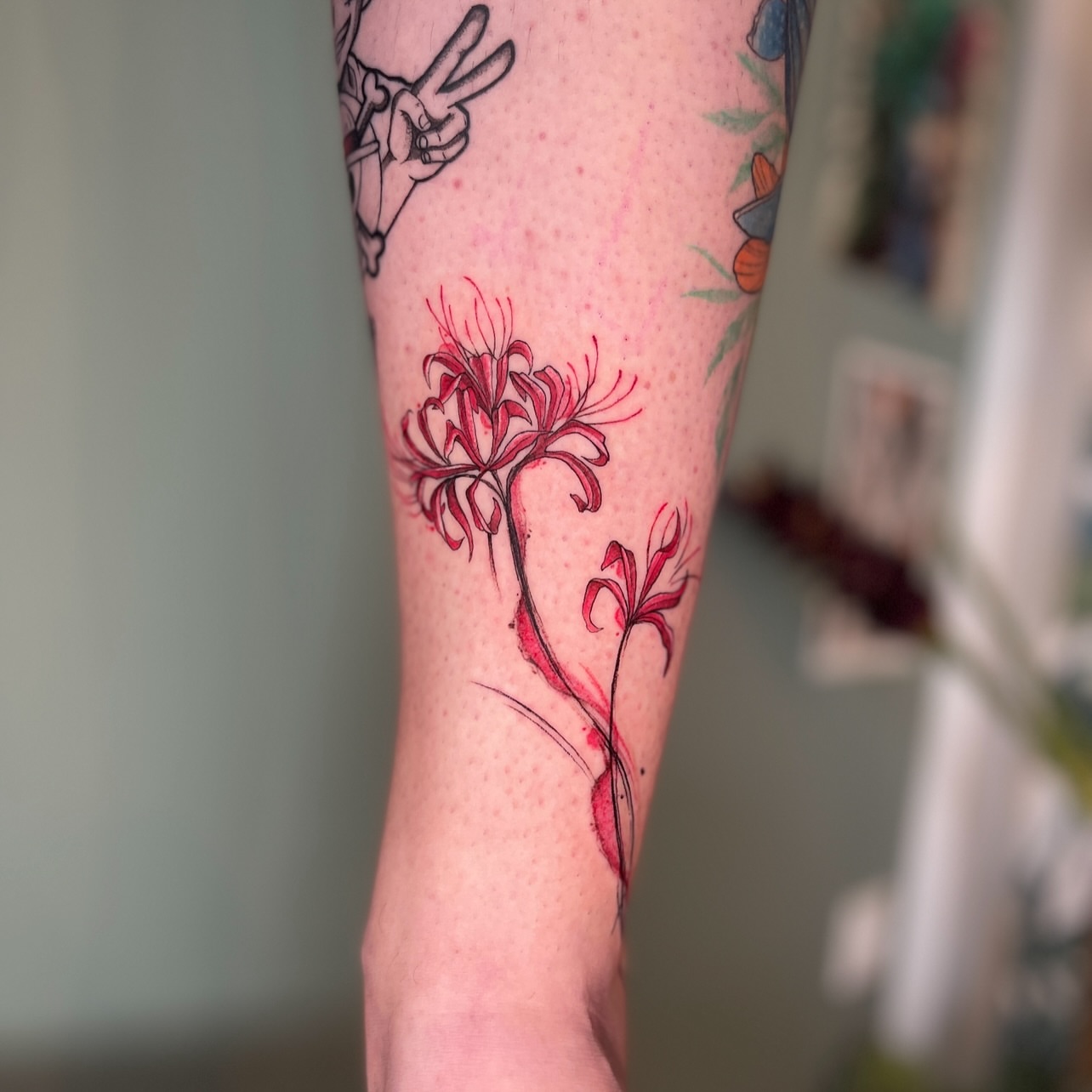 Red spider lilies watercolor tattoo on the forearm by Lo Boverod - La Passoire  - Tatoueuse -