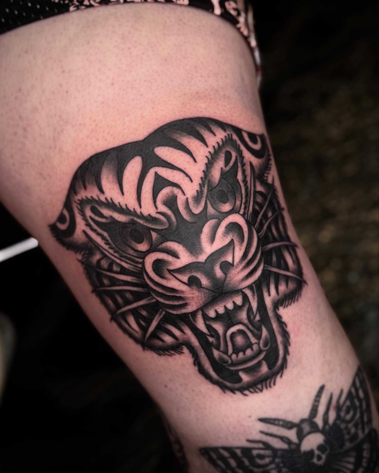 Tiger head black and grey tattoo on the thigh by Meg Nefcy, Milford, Michigan