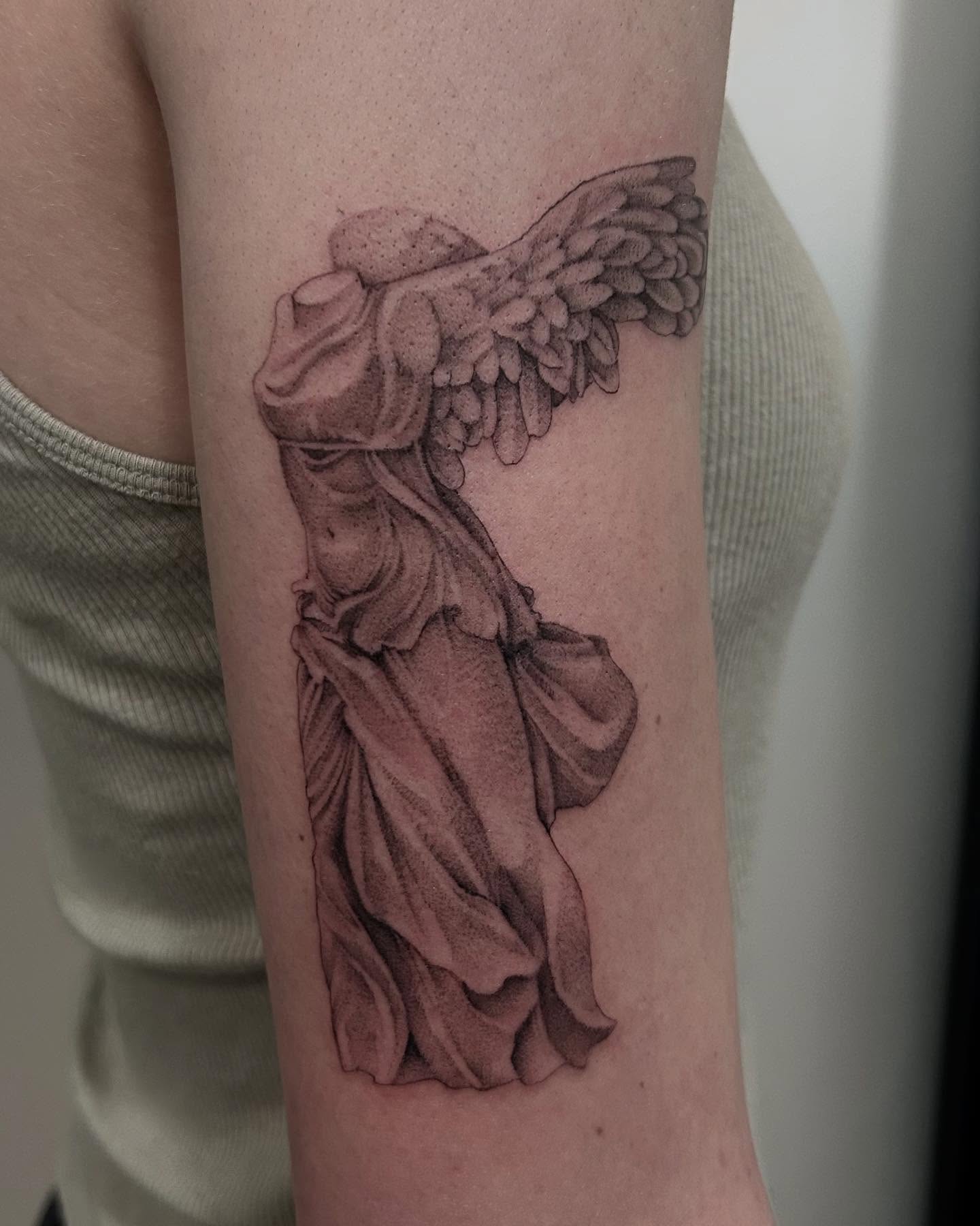 Statue of winged female figure realism tattoo on the forearm by Olivia Fox