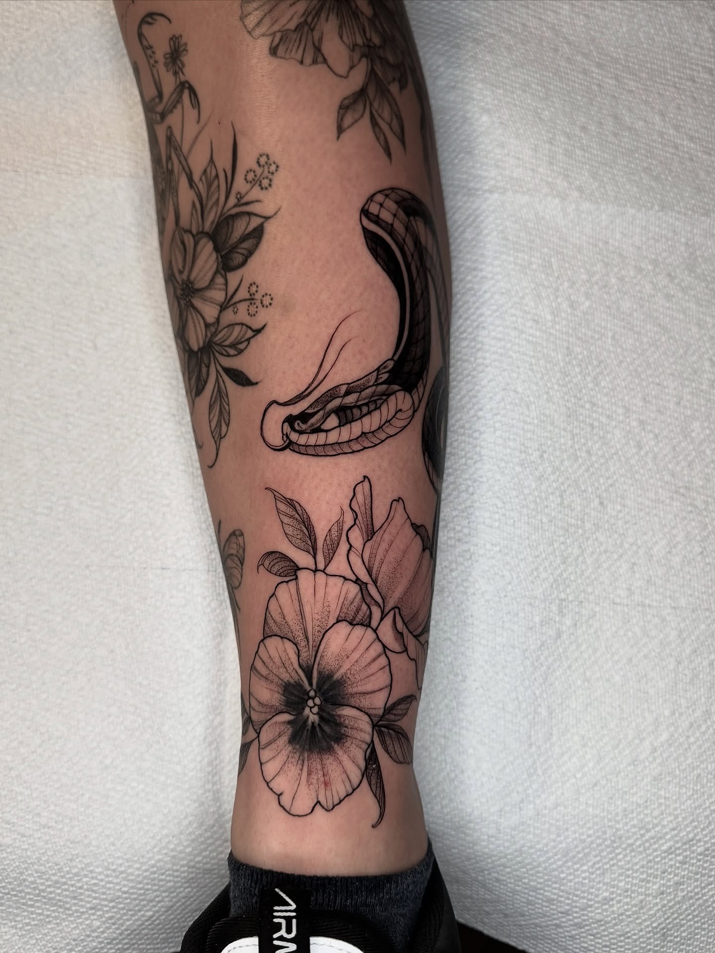 Snake and flowers black and grey tattoo on the forearm by Las Vegas Tattoo Artist