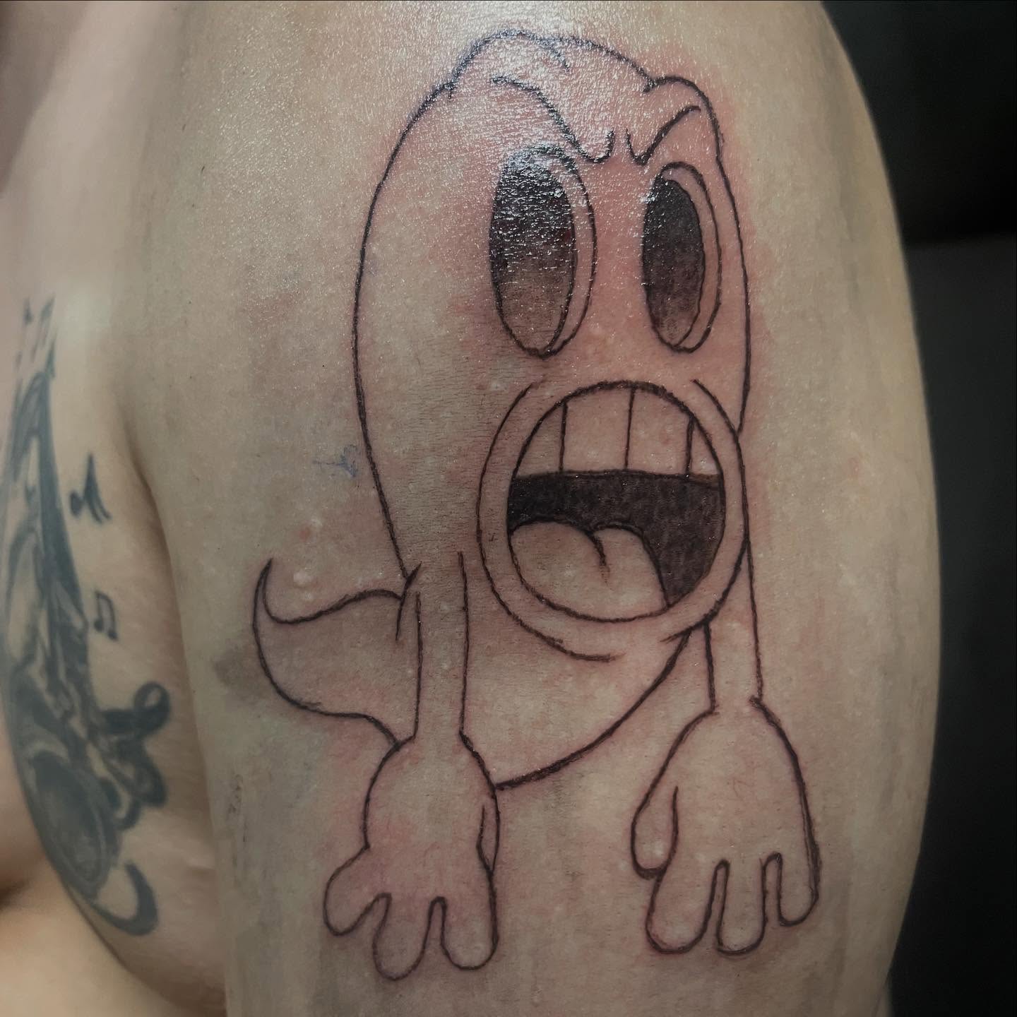 Scared ghost black and grey tattoo on the upper arm by Ink_ Hustle36