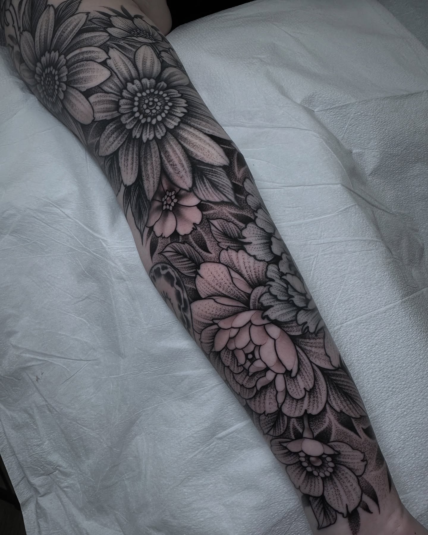 Floral bouquet black and grey tattoo on the forearm by Patrick Whiting