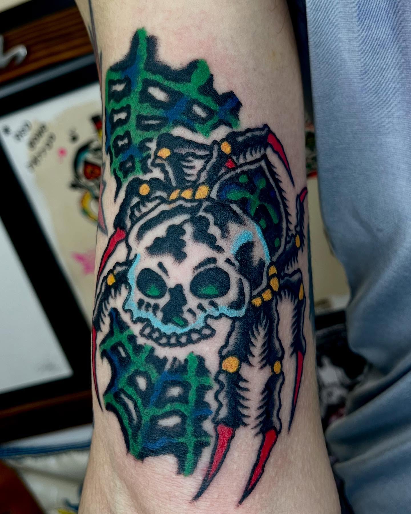 Skull with feathers American traditional tattoo on the forearm by Jimmy Ho