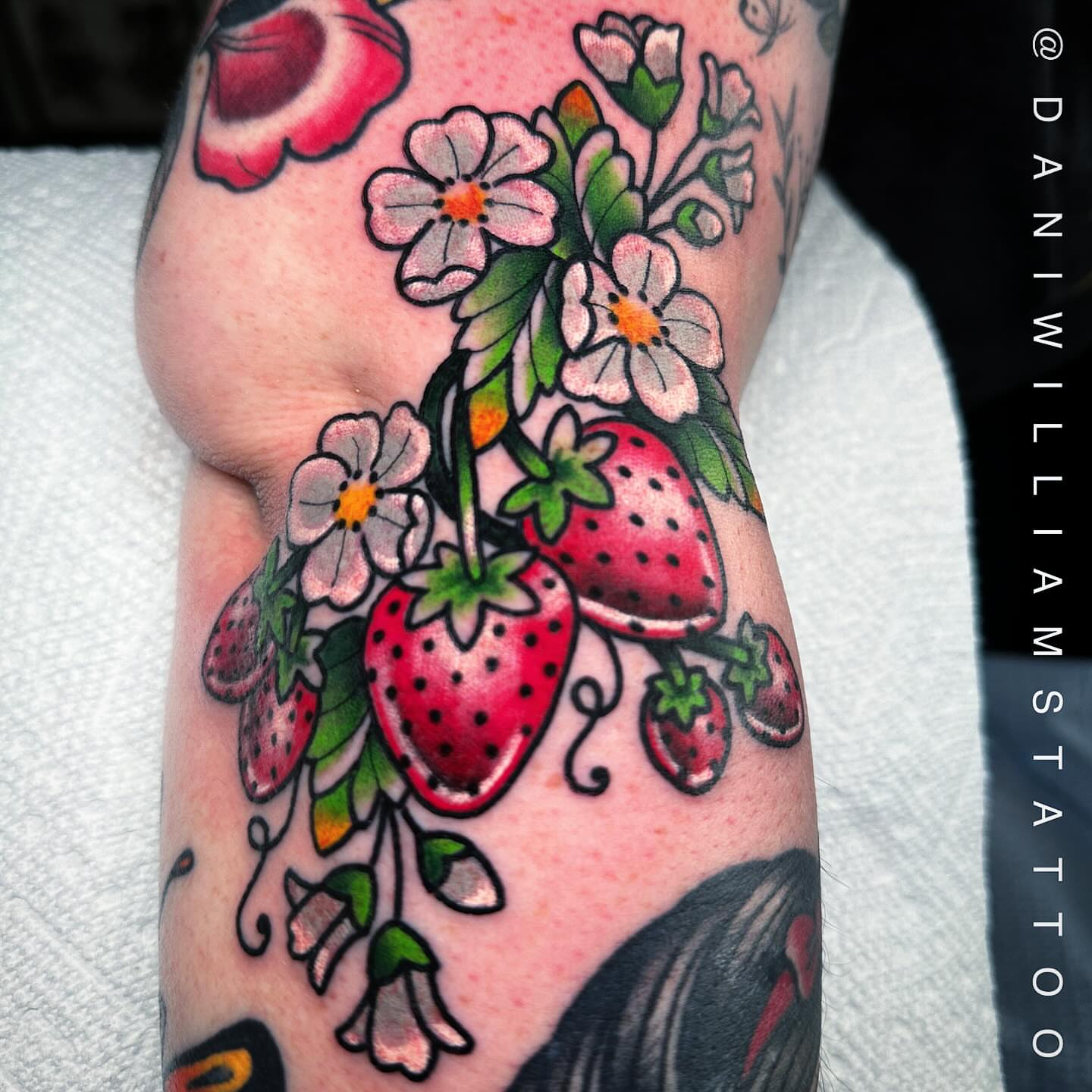 Strawberries and flowers American traditional tattoo on the forearm by Dani Johnson