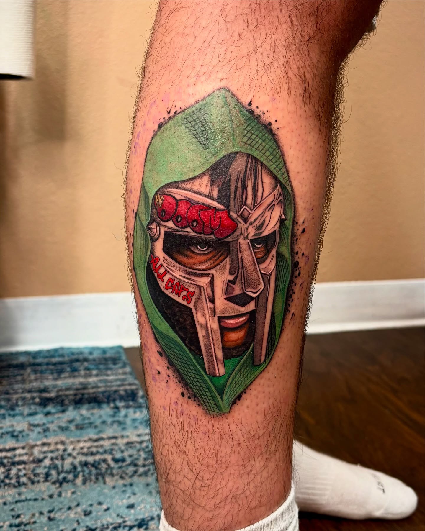 Mask with red eyes realism tattoo on the leg by Alexandria Gudiel