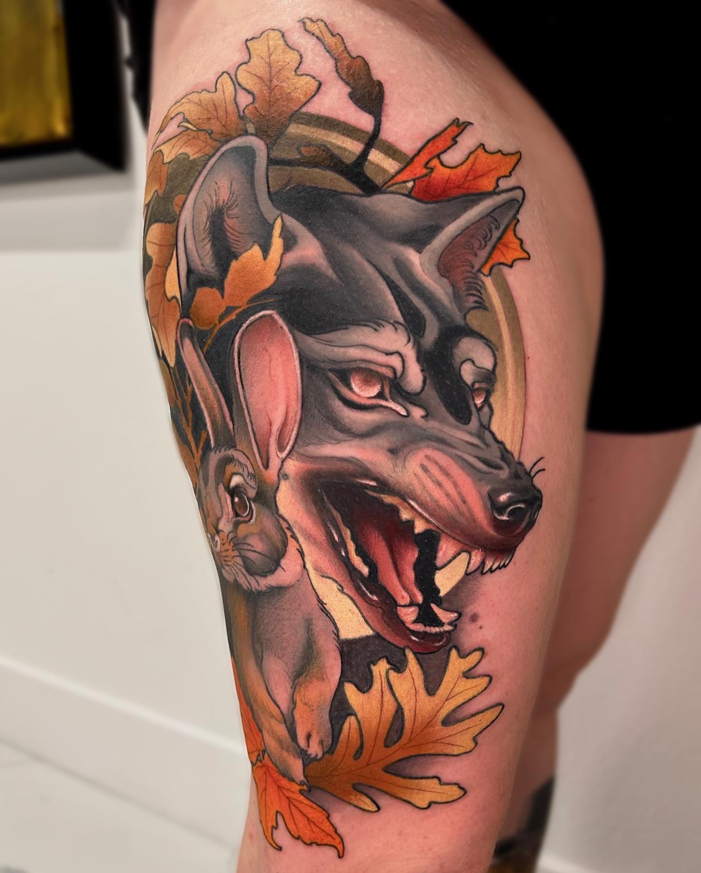Wolf and rabbit American traditional tattoo on the thigh by Levi Murphy