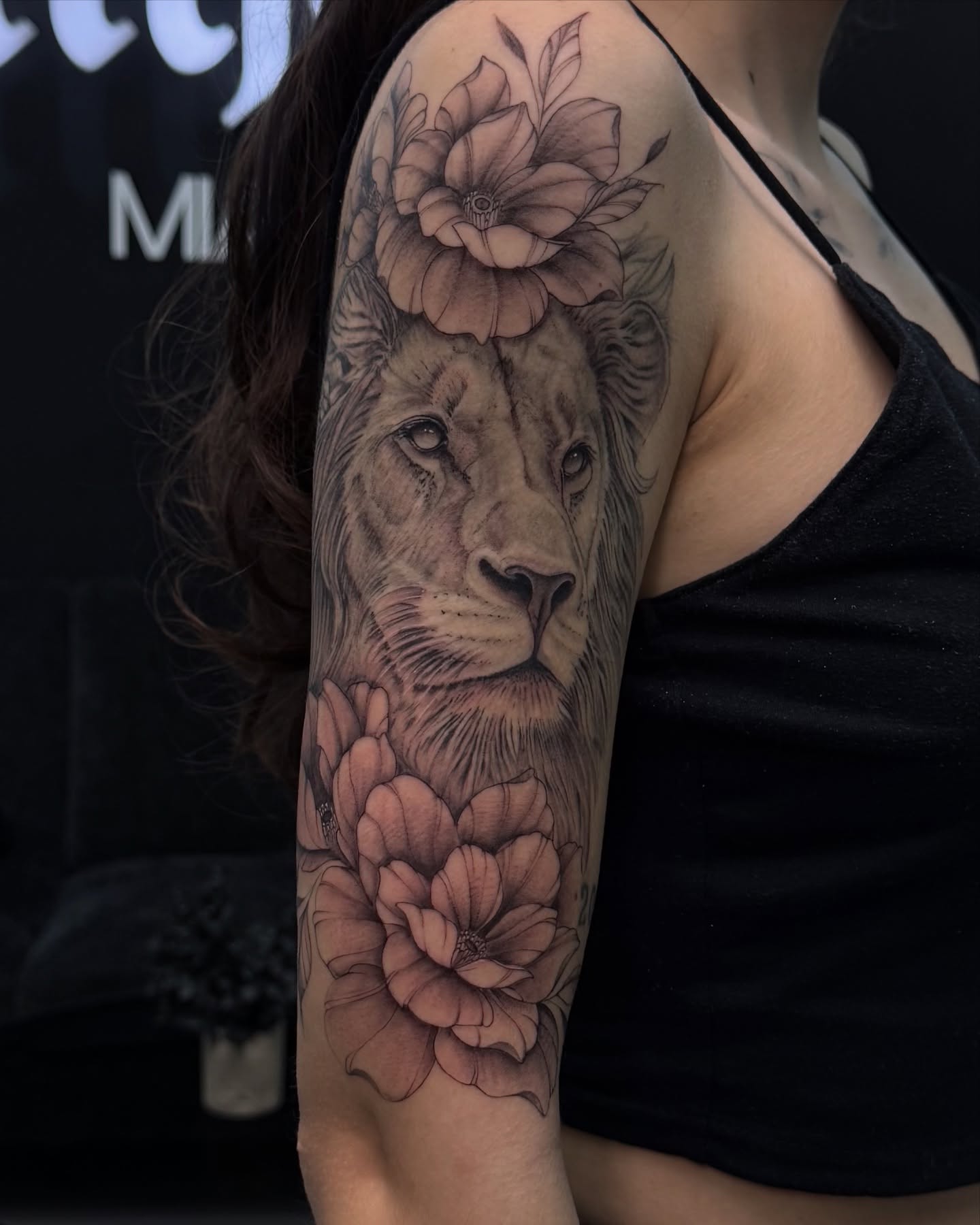 Lion with flowers realism tattoo on the forearm by Nicolas Herrera
